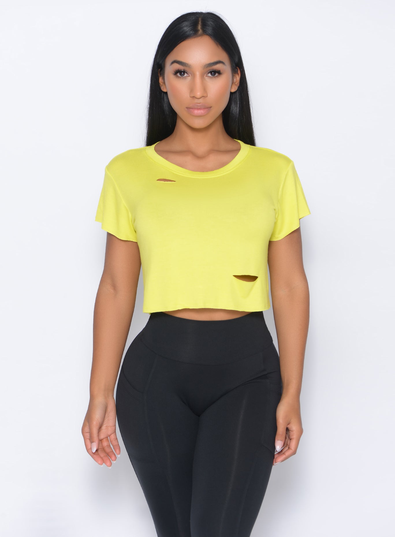 Model facing forward in our shredded tee in neon yellow and a high waist black leggings
