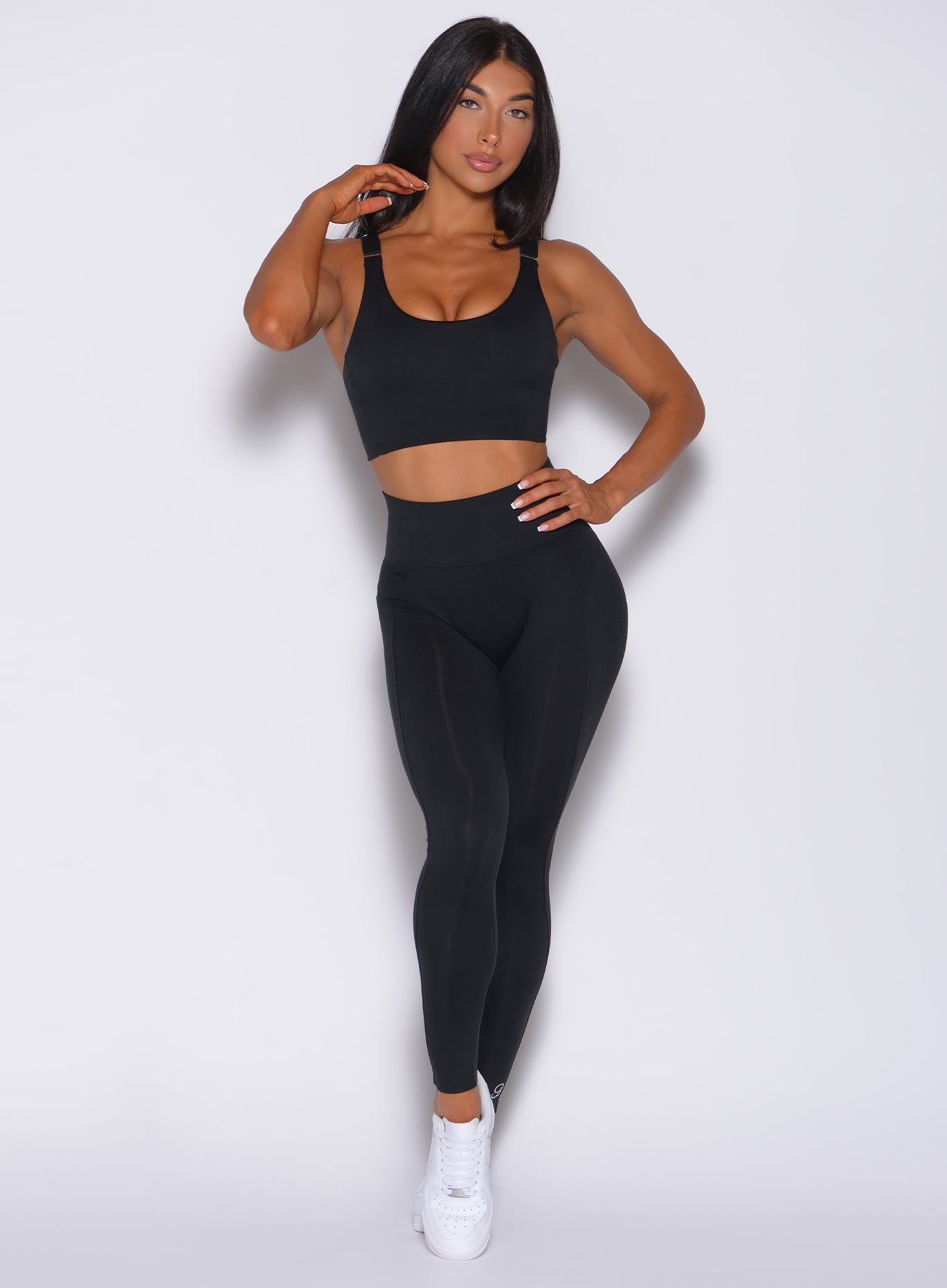 Front profile view of a model in our black snatched waist leggings and a matching bra 