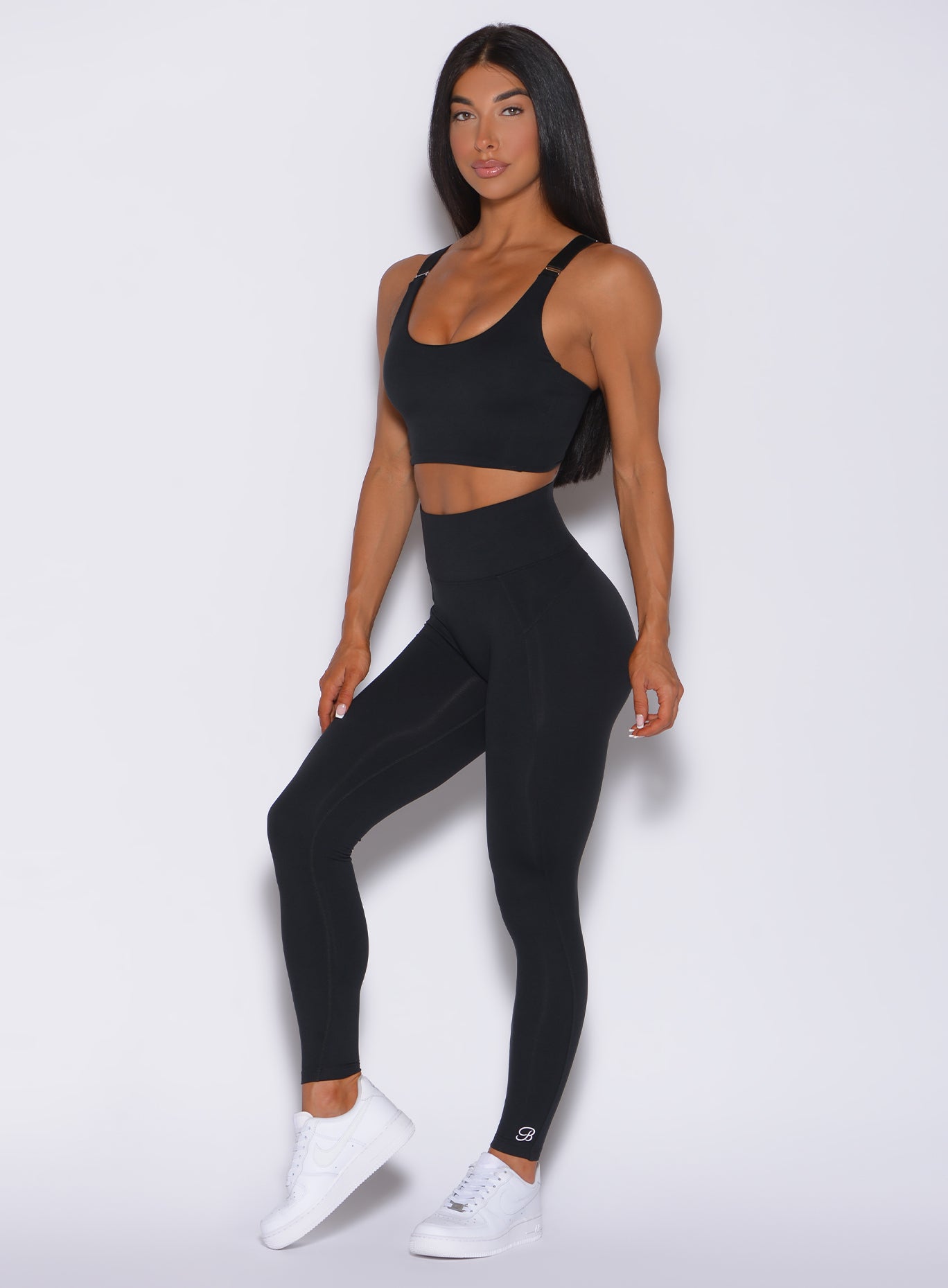 Left side profile view of a model in our black snatched waist leggings and a matching bra