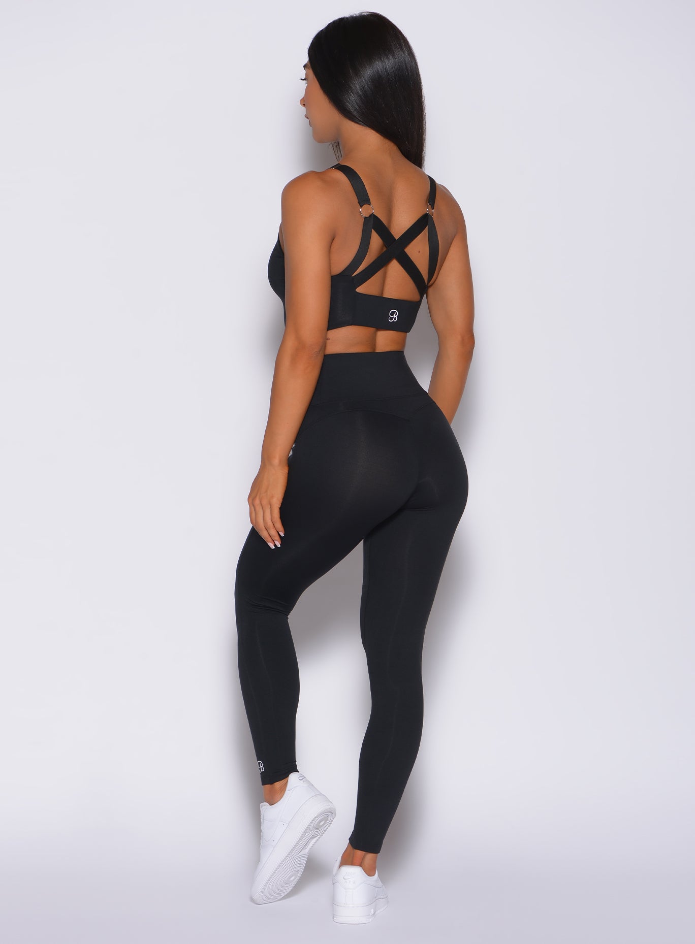 Back profile view of a model in our black snatched waist leggings and a matching bra