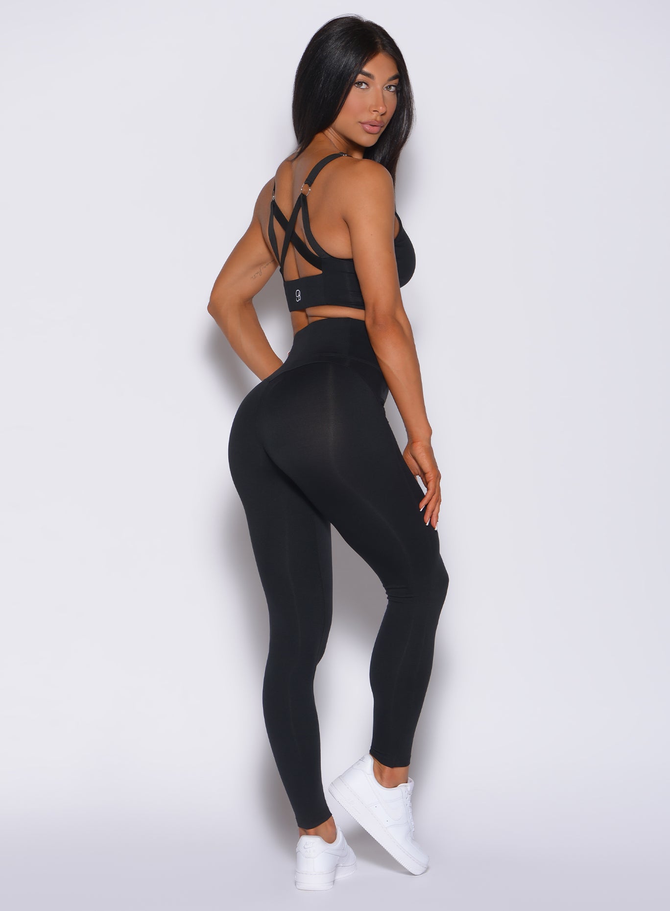 Right side profile view of a model in our black snatched waist leggings and a matching bra