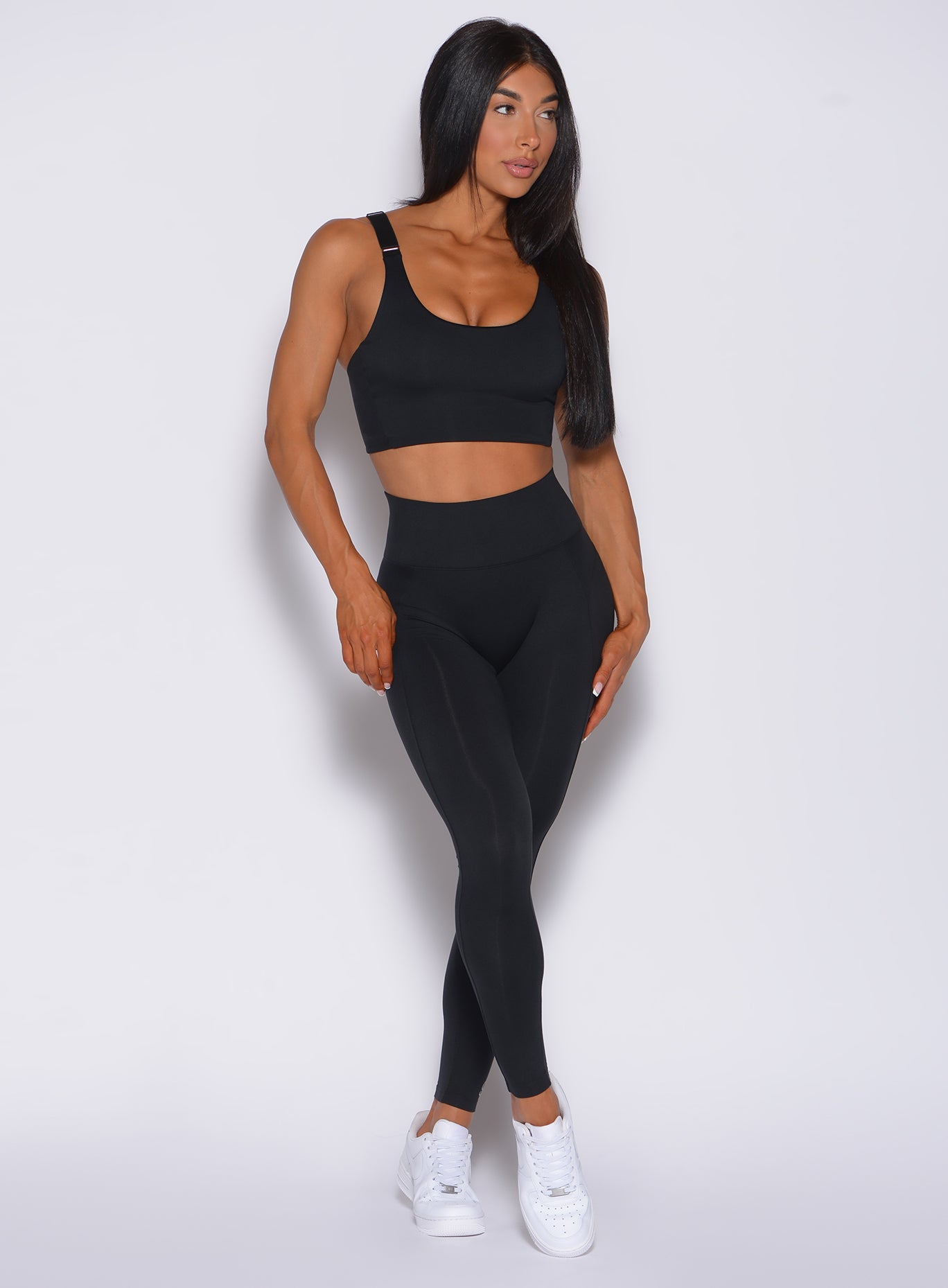 Front profile view of a model in our black snatched waist leggings and a matching sports bra