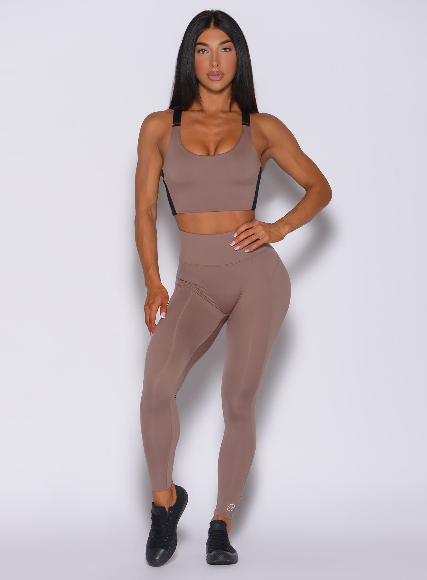 Front profile view of the model wearing our snatched waist leggings in cocoa color and a matching bra