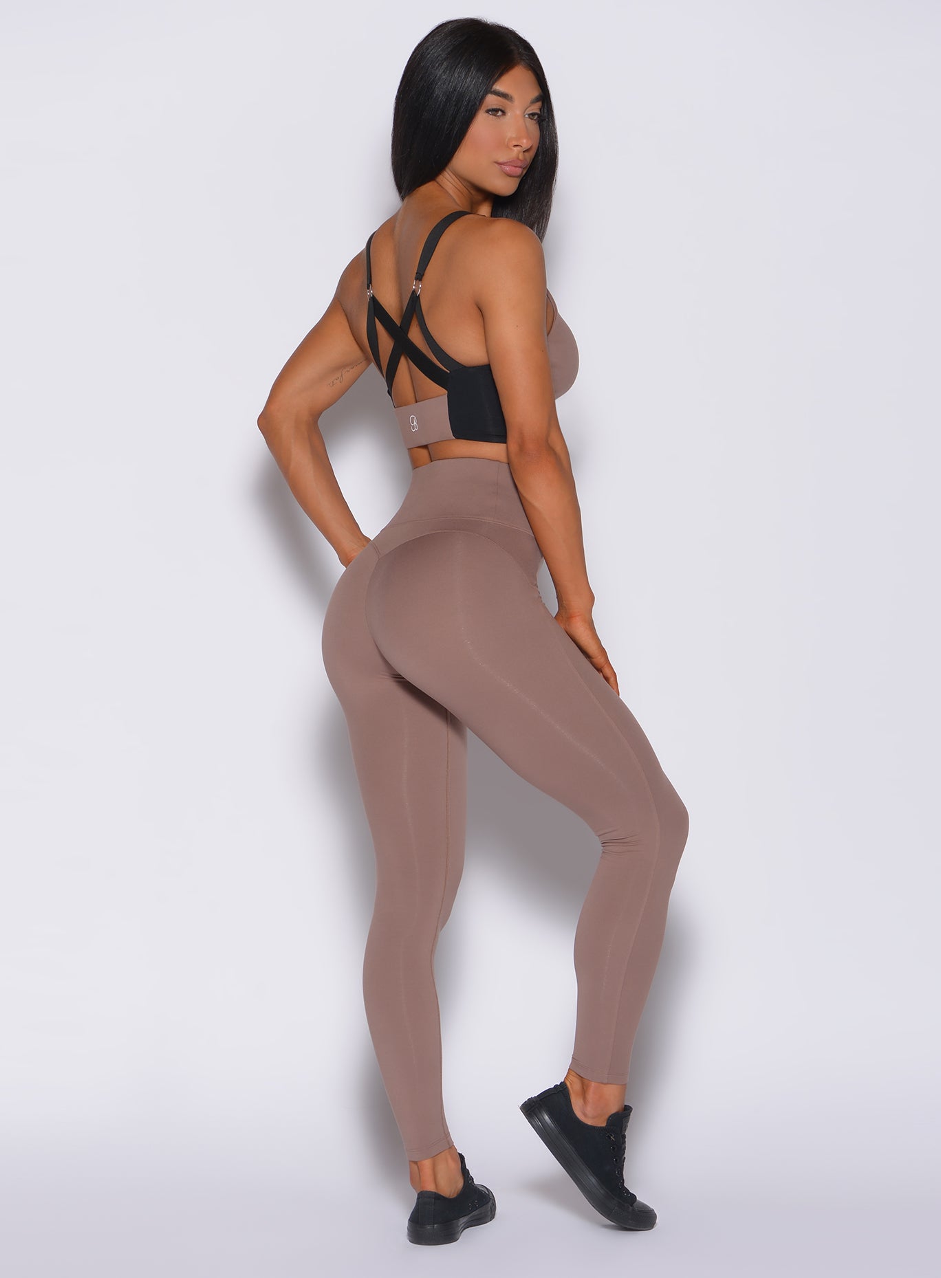 Right side profile view of a model in our snatched waist leggings in cocoa color and a matching bra