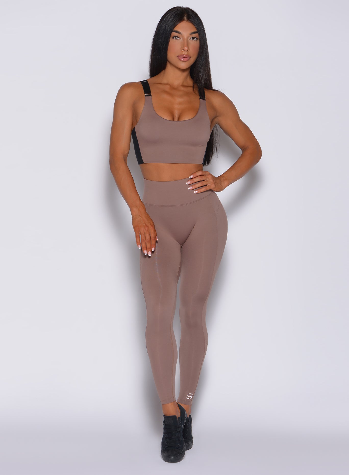 Front profile view of a model in our snatched waist leggings in cocoa color and a matching bra