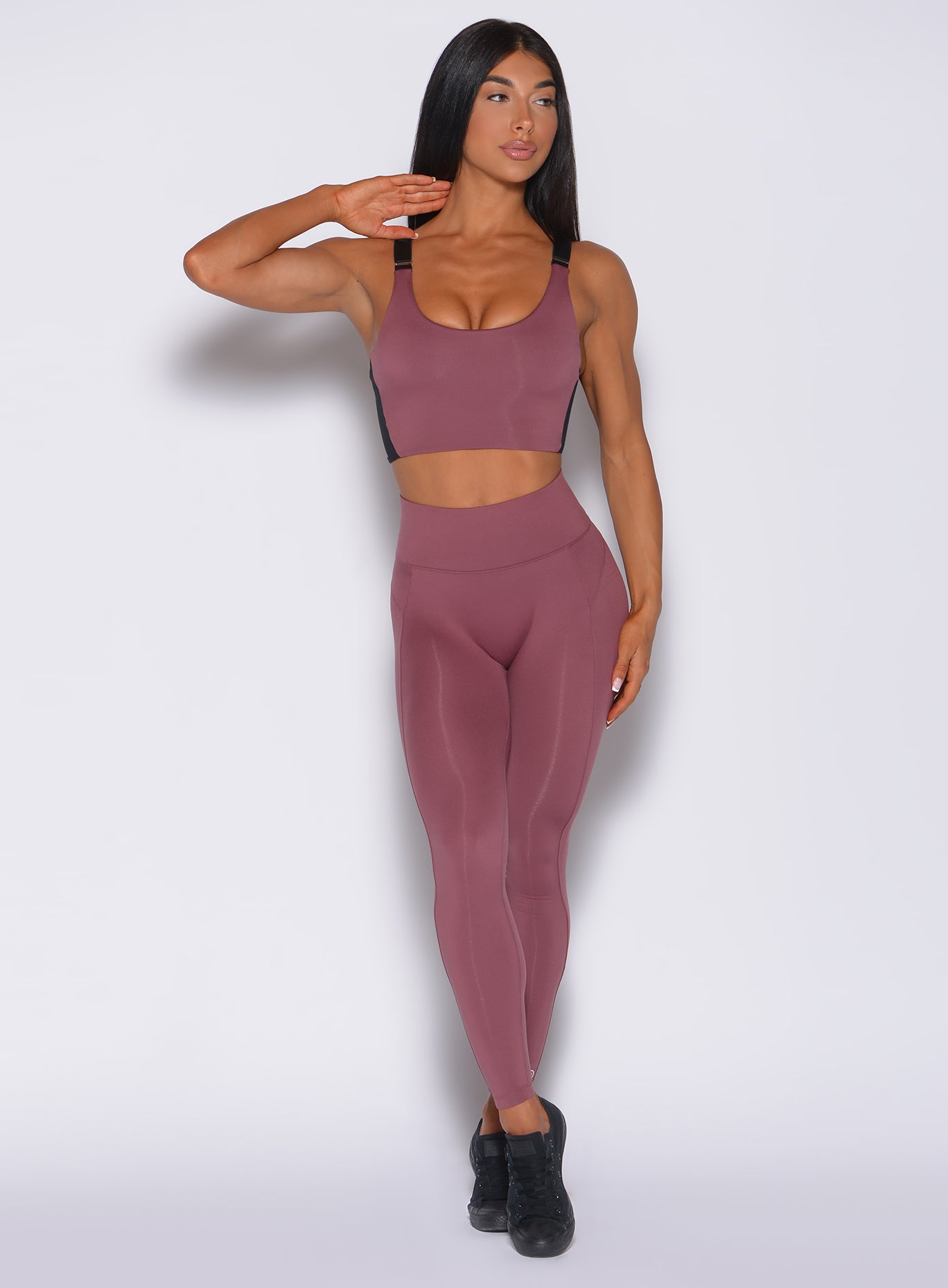 Front profile view of a model in our snatched waist leggings in merlot color and a matching bra 