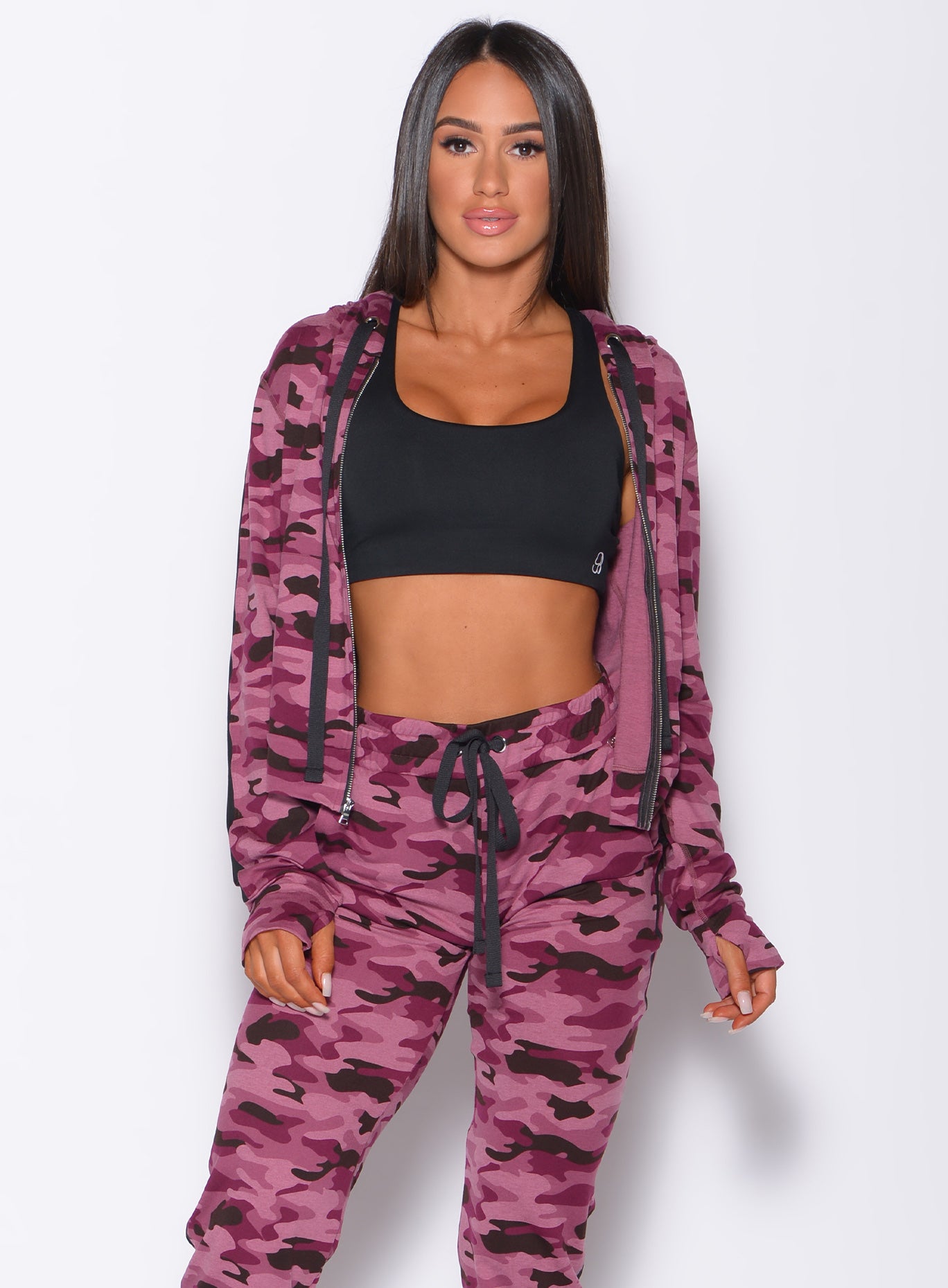 Front profile view of a model wearing our dream jacket in Purple Power Camo color and a matching joggers