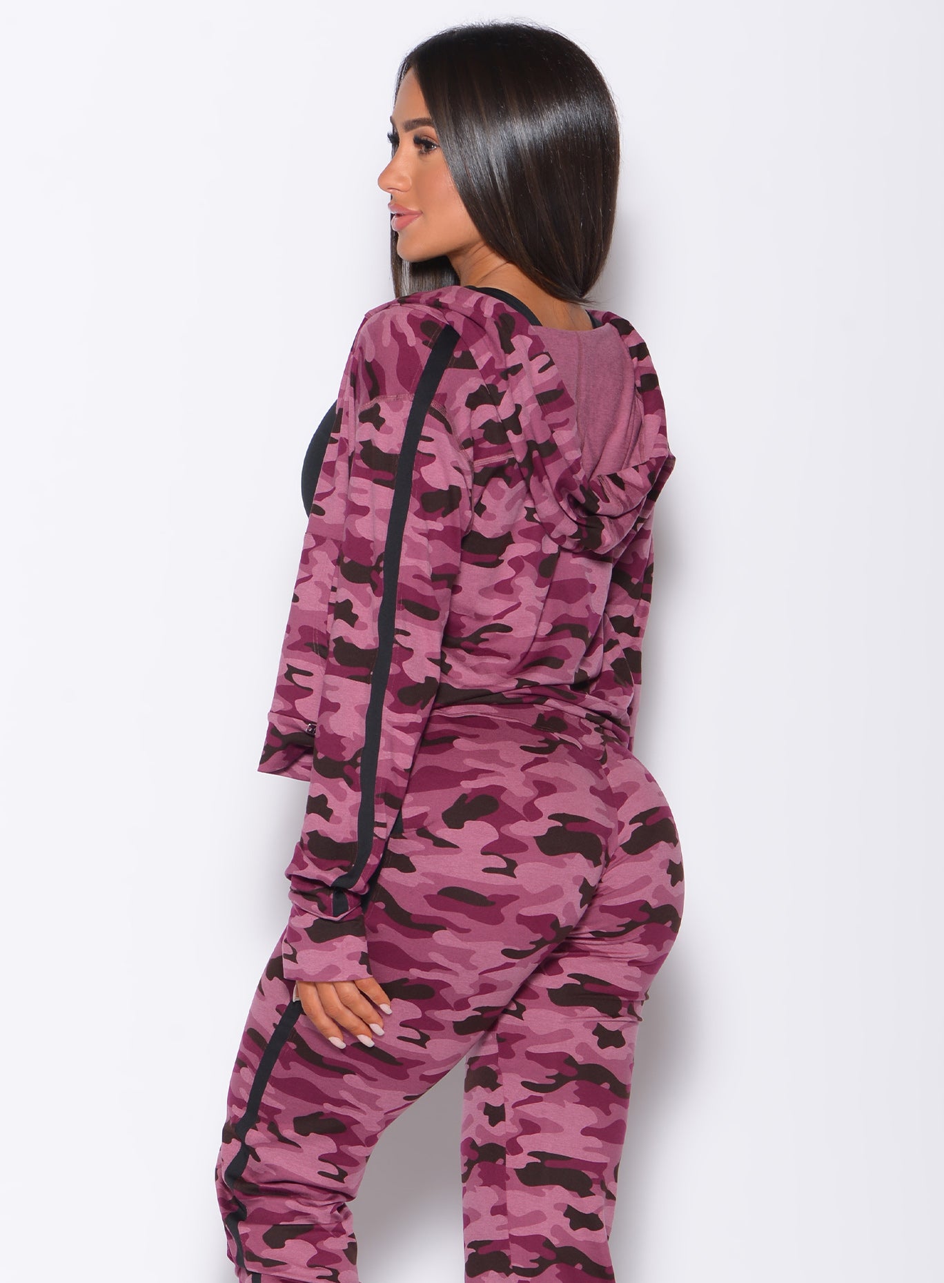 Left side profile view of a model wearing our dream jacket in Purple Power Camo color and a matching joggers