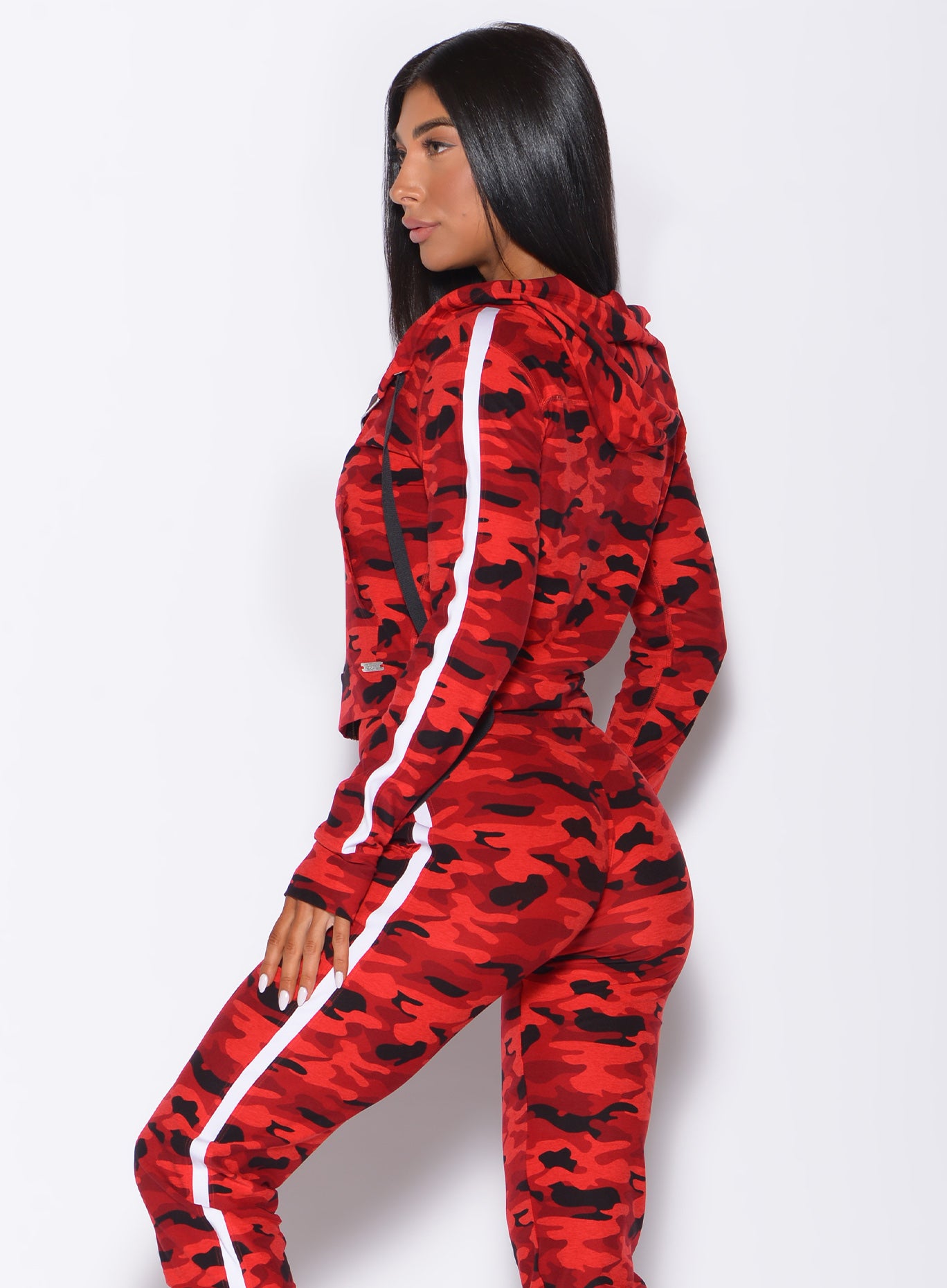 Left side profile view of a model wearing our dream jacket in Red Rebel Camo color and a matching joggers