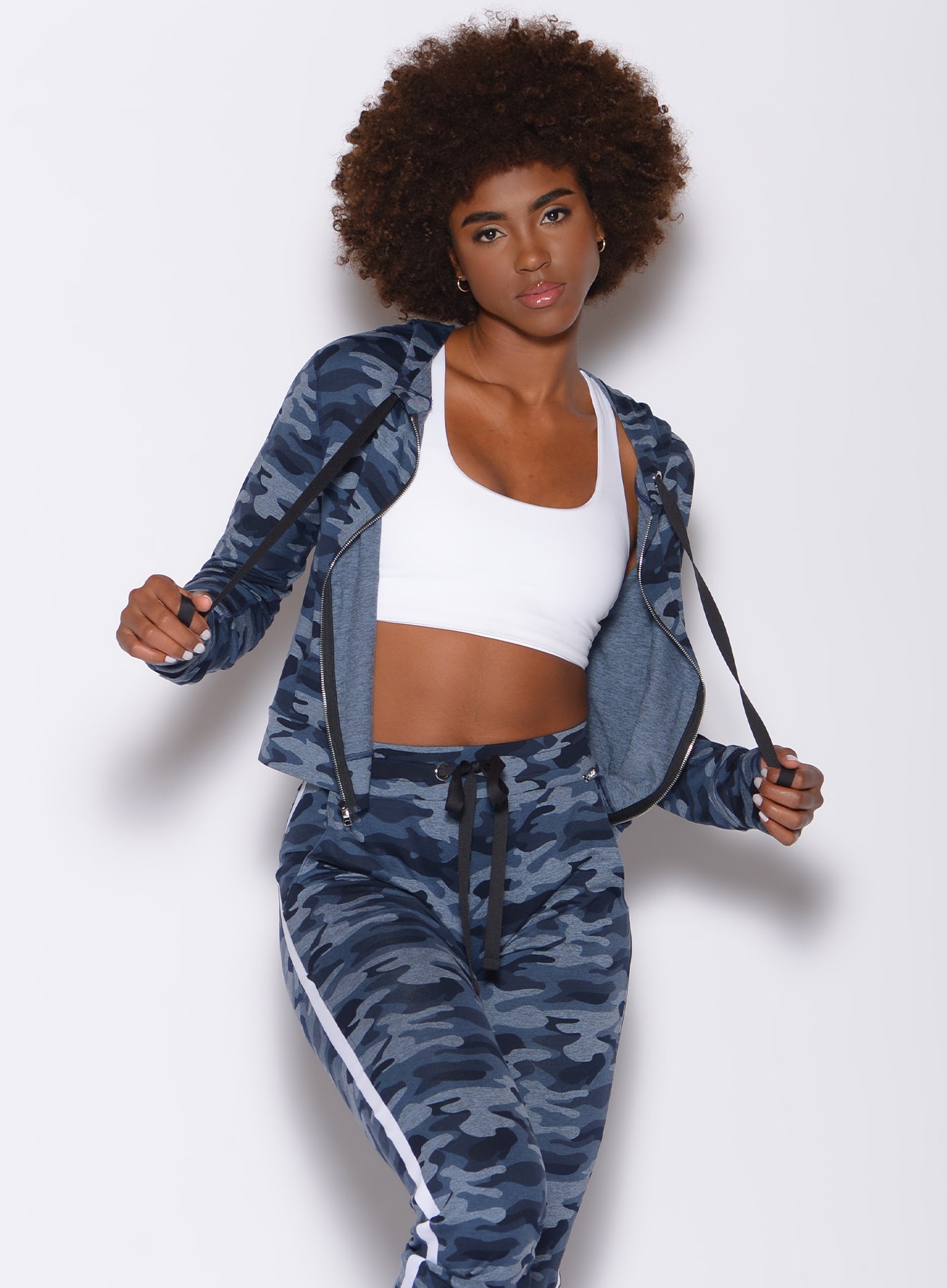 Front profile view of a model wearing dream jacket in Blue Blast Camo color and a matching dreamjoggers