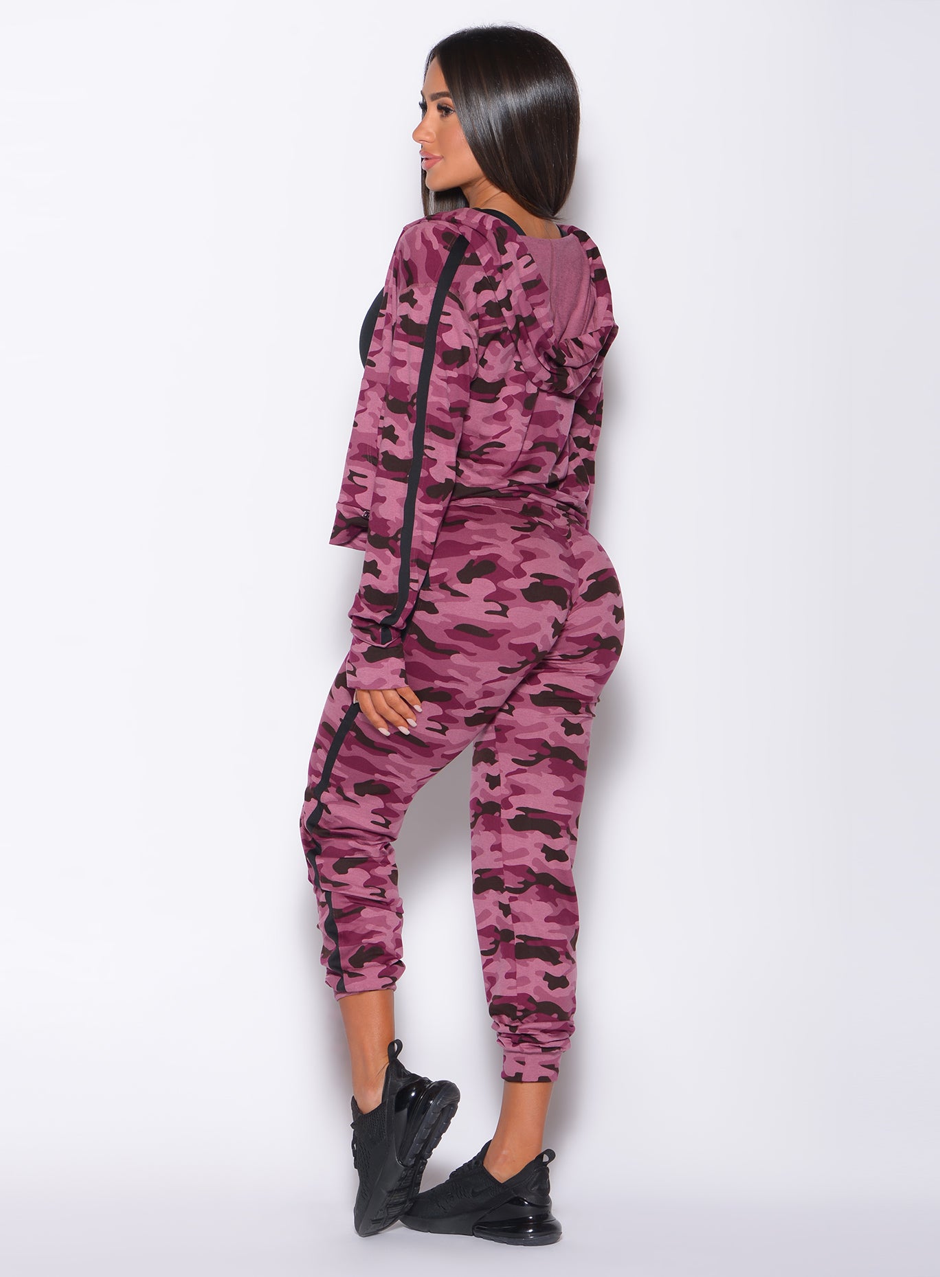 Left side  profile view of a model in our dream joggers in Purple Power Camo color and a matching long sleeved jacket