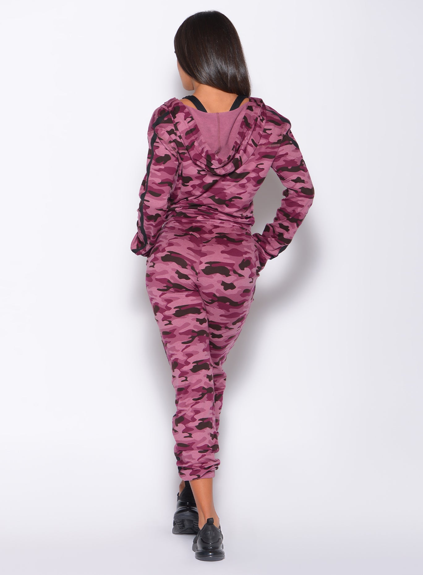 Back profile picture of a model wearing our dream jacket in Purple Power Camo color and a matching joggers
