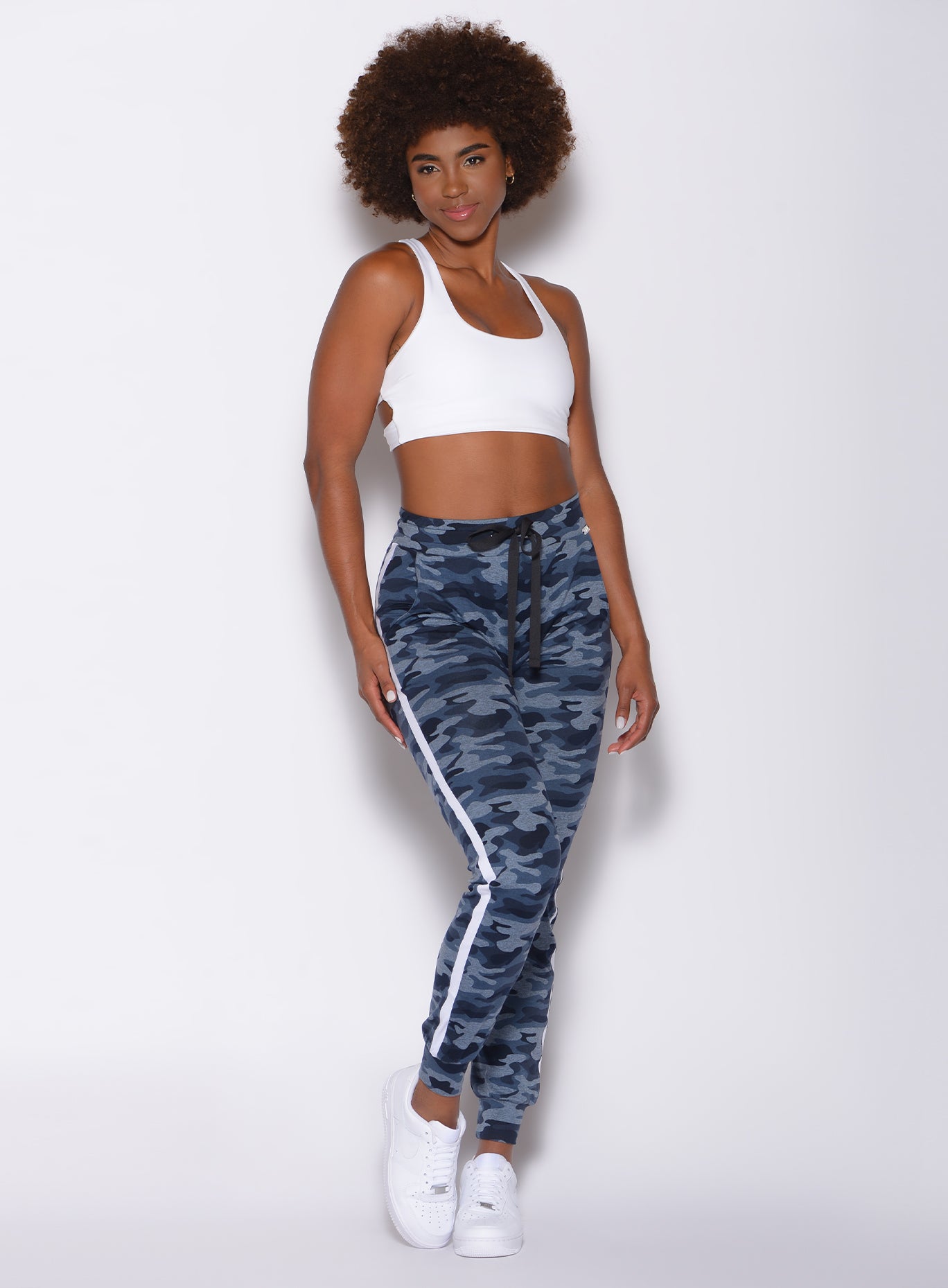 Model facing forward wearing our dram joggers in Blue Blast Camo color and a white sports bra 