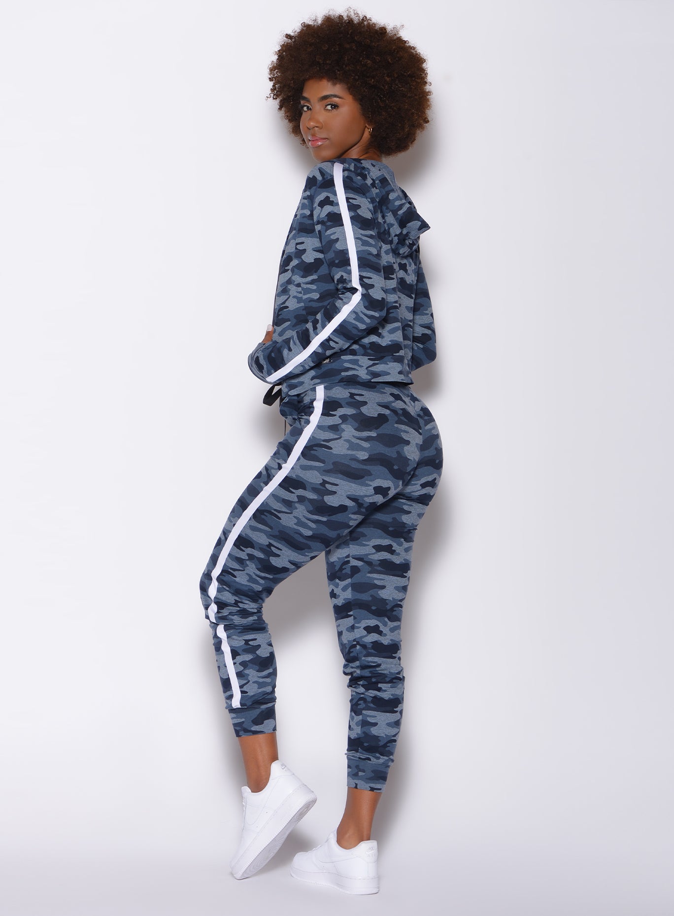 Left side profile view of a model facing to her left wearing our dream joggers in Blue Blast Camo color and a matching jacket