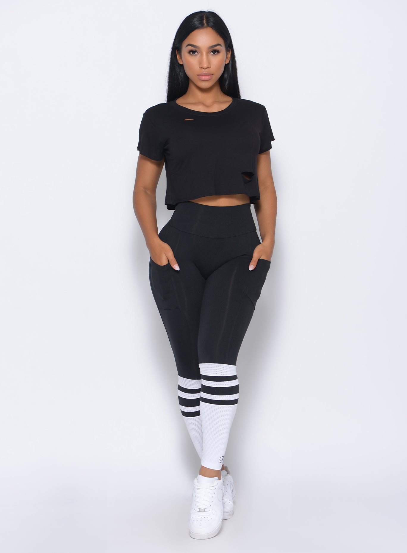 Front profile view of the model in our black perform sock leggings and a matching top