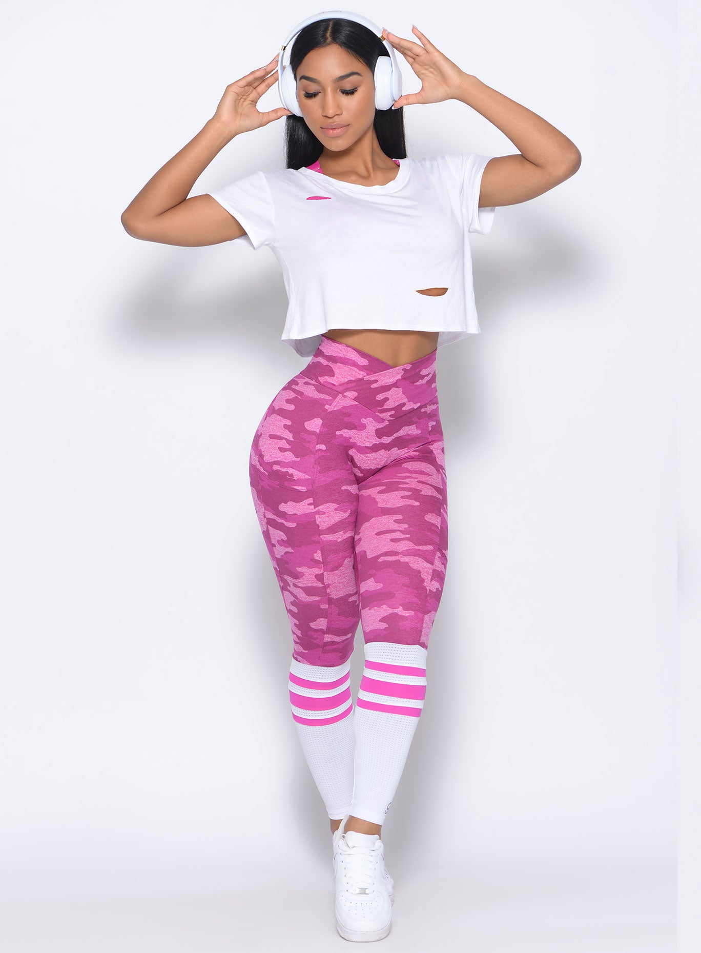 Front profile view of the model in our contour sock leggings in pink camo and a white top