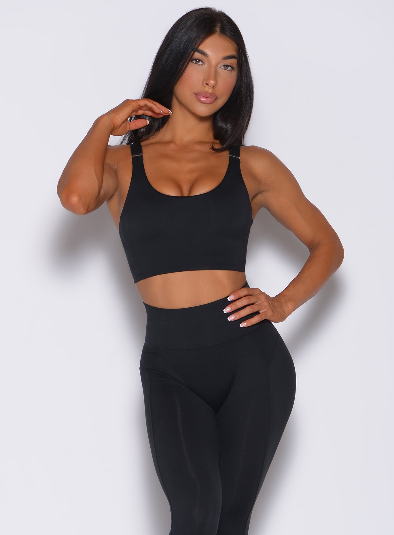 Front profile view of a model facing forward wearing  our banded sports bra in black and a matching leggings