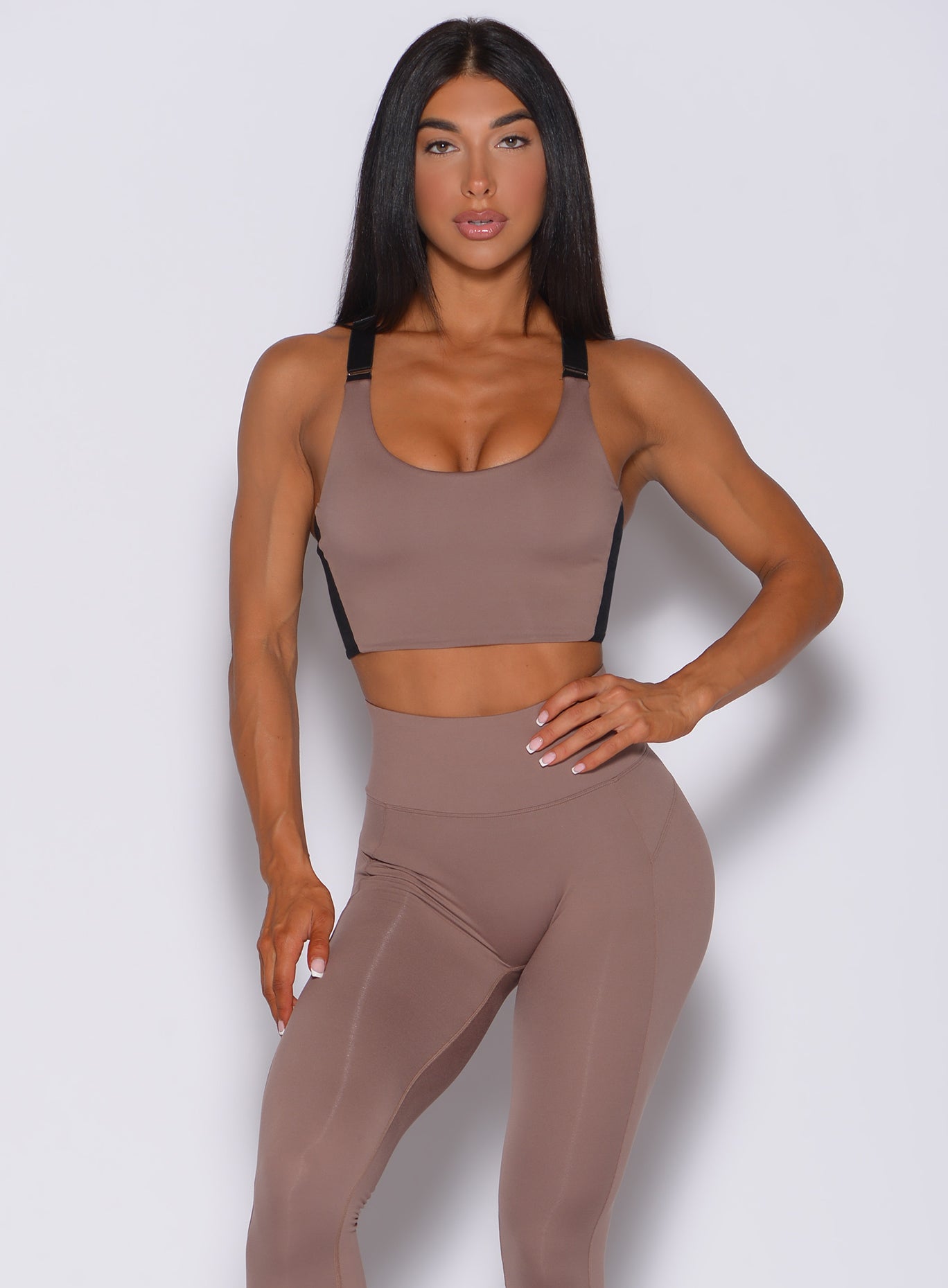 Front profile view of a model in our banded sports bra in cocoa color and a matching leggings