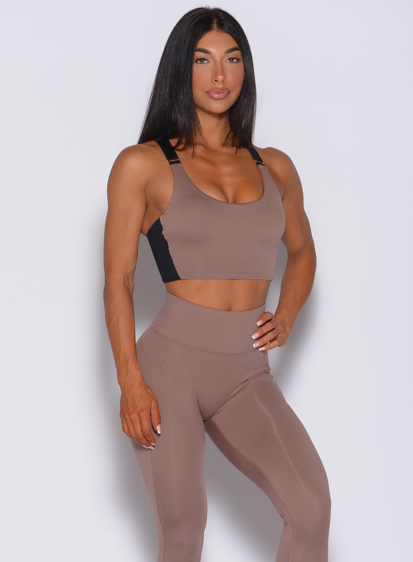 Model facing forward wearing our banded sports bra in cocoa color and a matching leggings