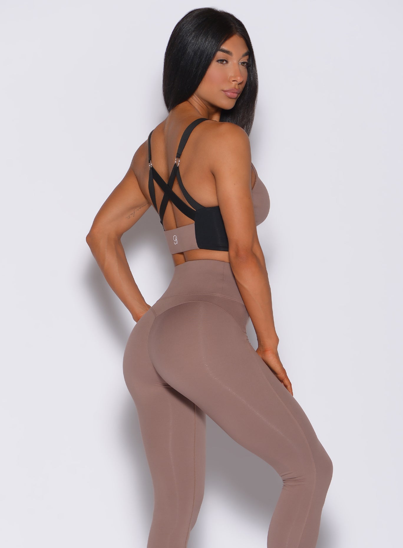 Right side profile view of a model in our banded sports bra in cocoa color and a matching leggings