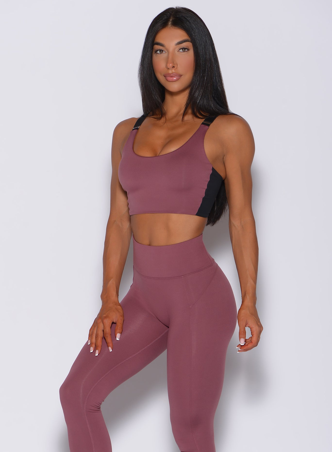 Model facing forward wearing our banded sports bra in merlot color and a matching leggings
