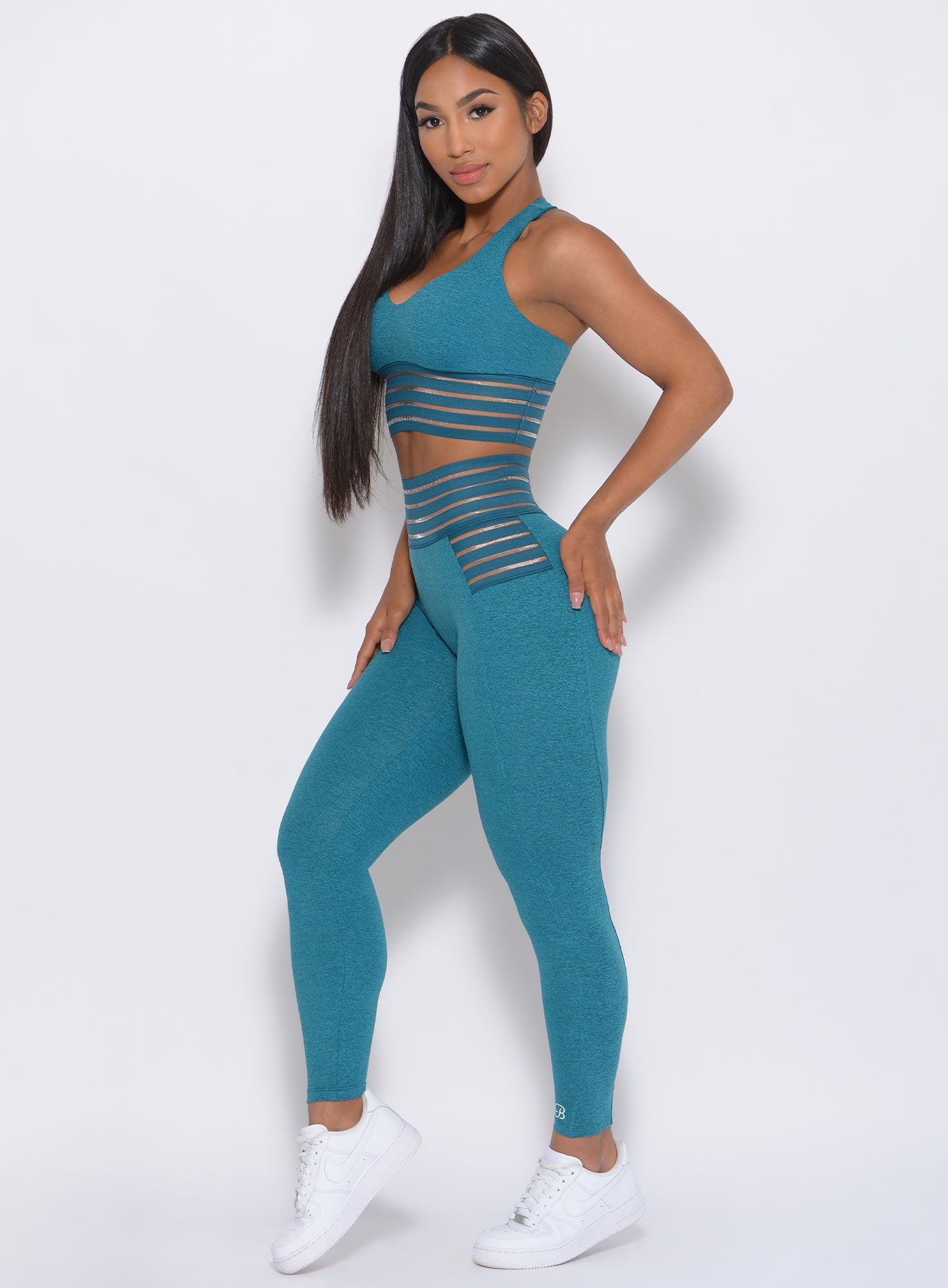 Left side profile view of the model in our statement leggings in seafoam color and a matching bra