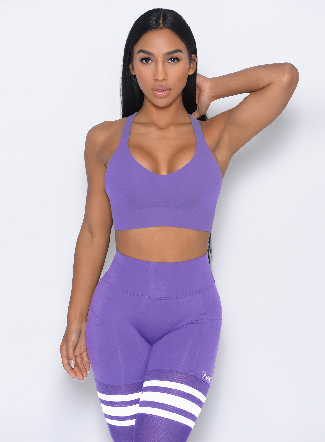 Model facing forward wearing our synergy sports bra in royal purple color and a matching leggings