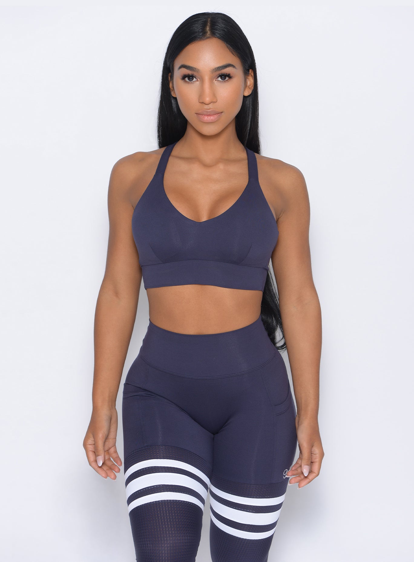 Front profile view of the model wearing  our synergy sports bra in twilight blue color and a matching leggings