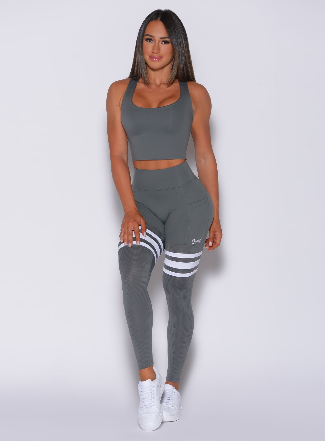 Front profile view of a model in our scrunch thigh high in steel gray color and a matching bra