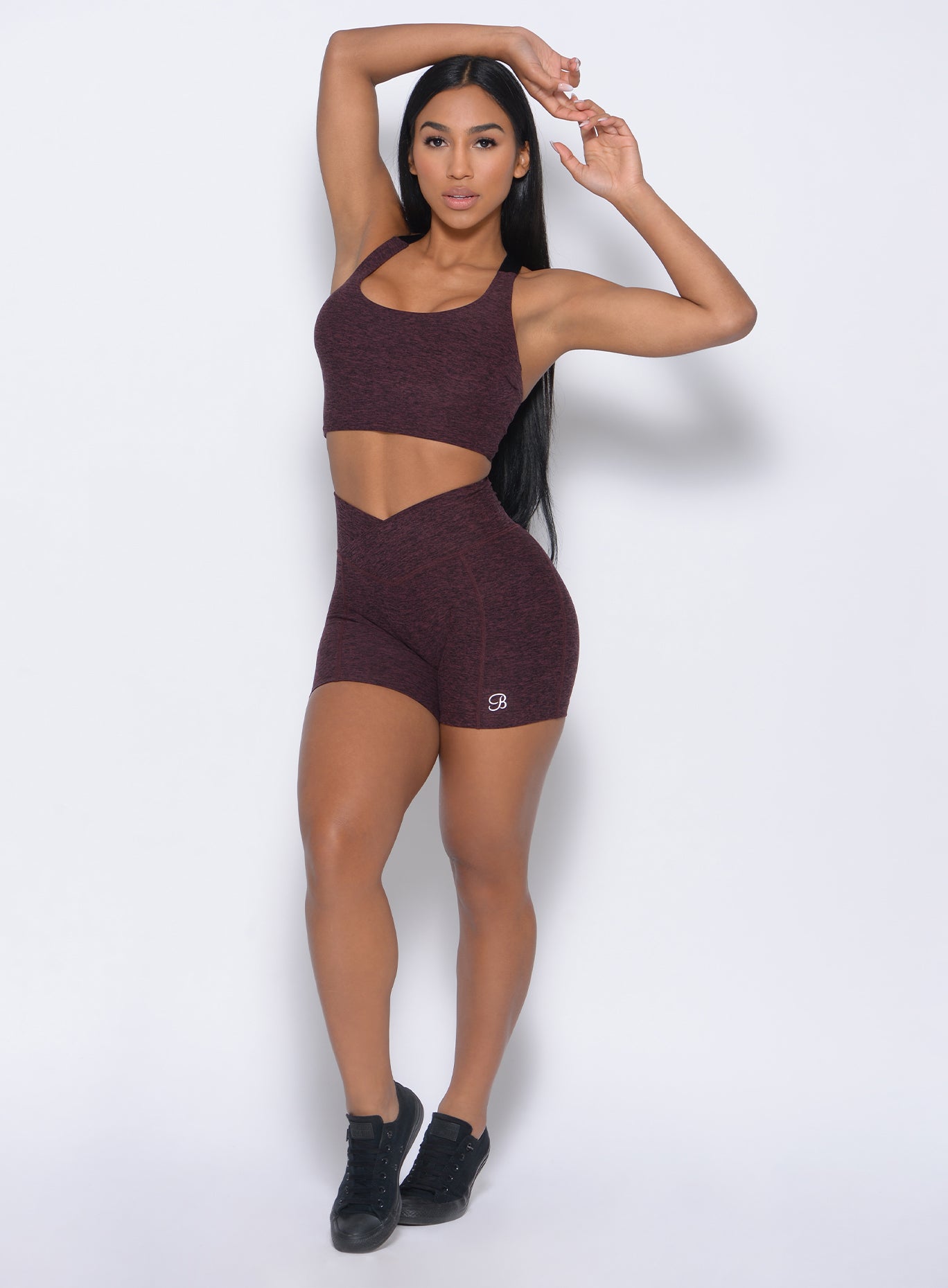 Front profile view of the model in our tiny waist shorts in port color and a matching bra