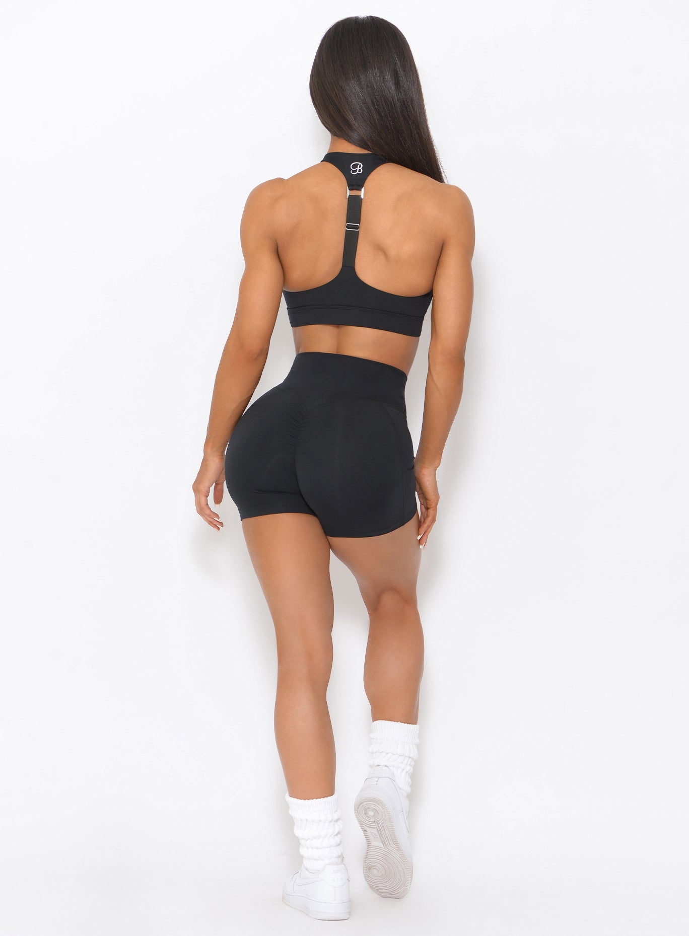 Back view of the model in our black tiny waist shorts and a matching top