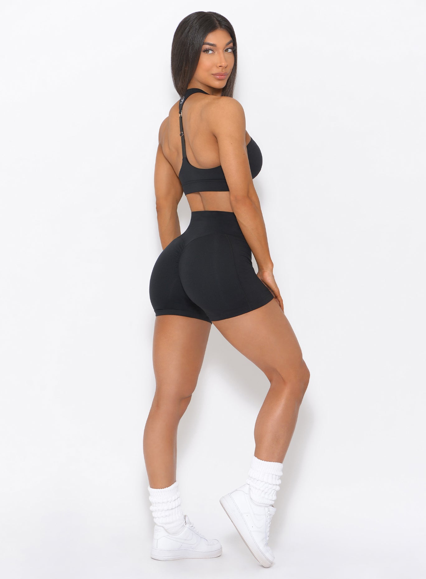 Right side view of the model in our black tiny waist shorts and a matching top