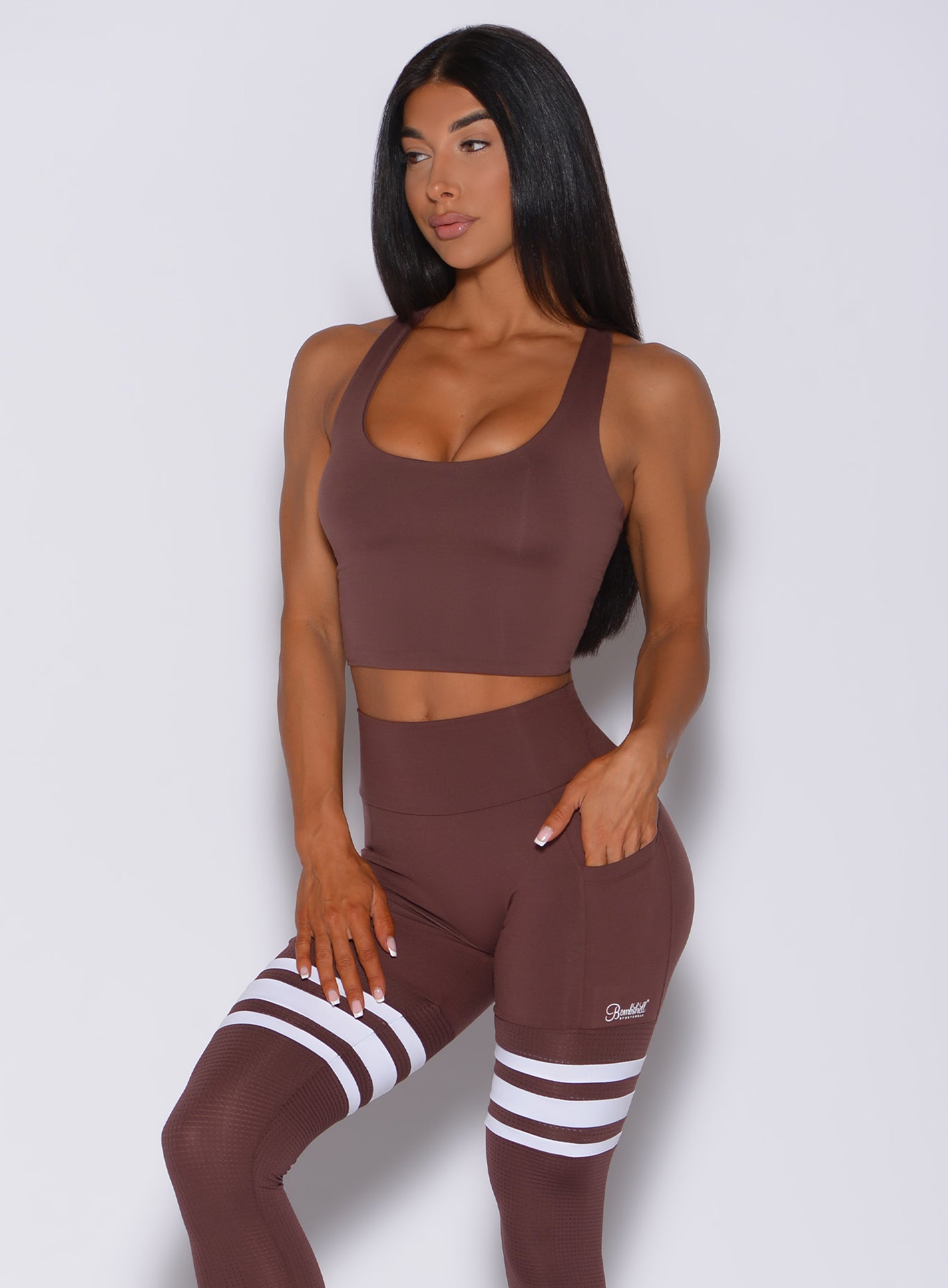 Front profile view of a model wearing our ultimate tank bra in chocolate color and a matching leggings