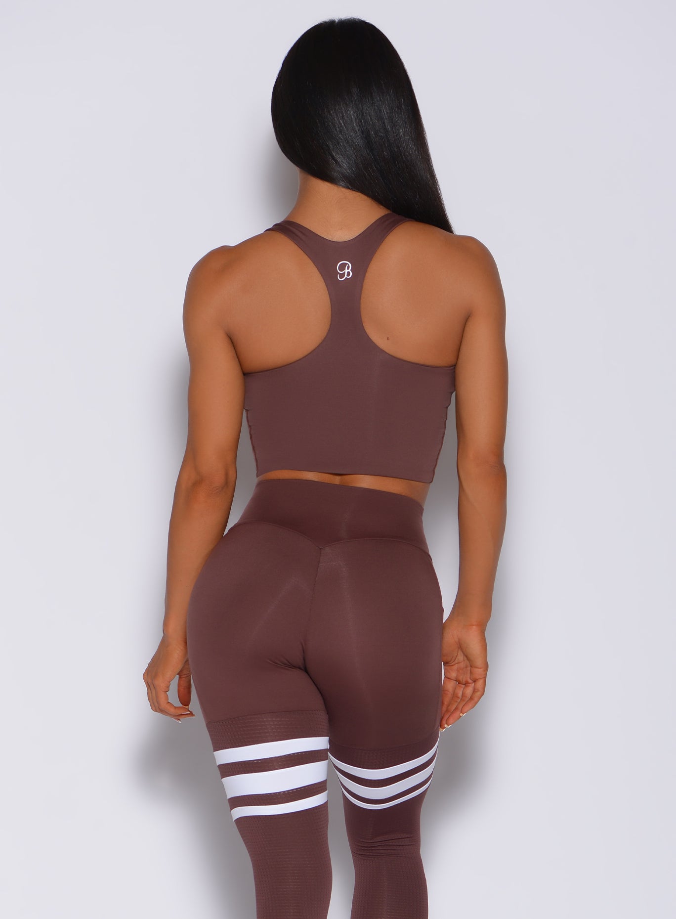 Back profile view of a model in our ultimate tank bra in chocolate color and a matching leggings