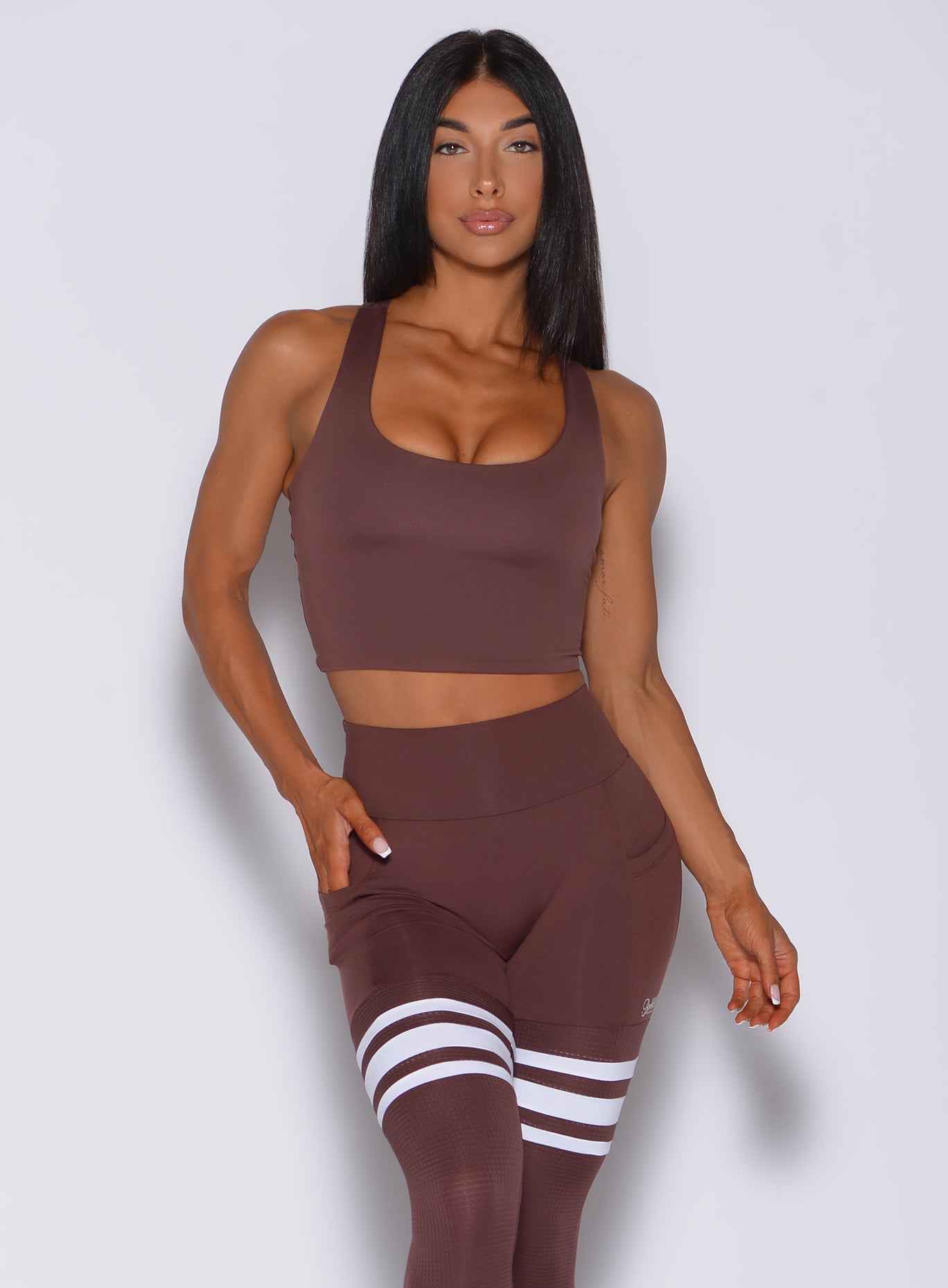 Front profile view of a model in our ultimate tank bra in chocolate color and a matching leggings 