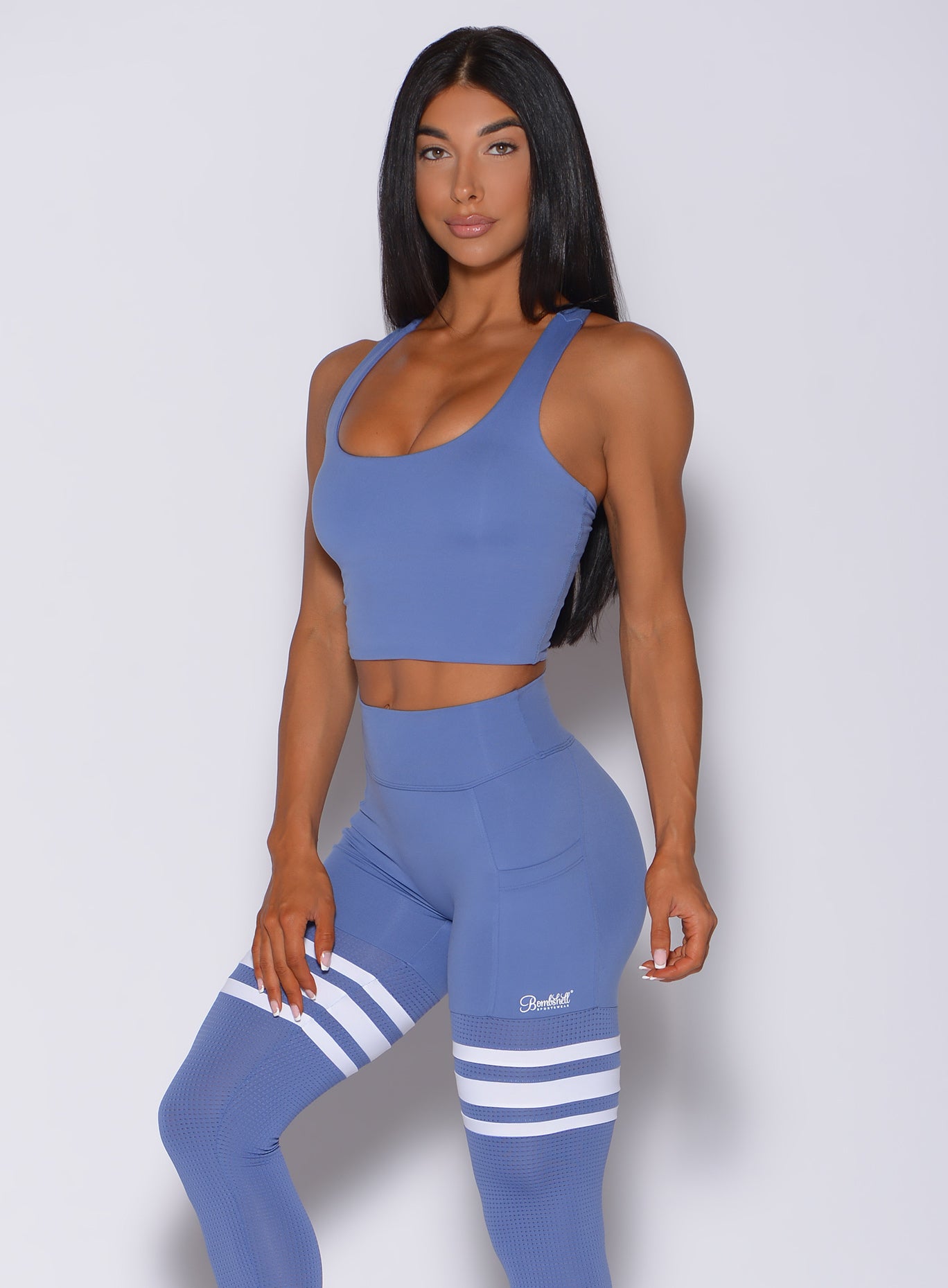 Front profile view of a model in our ultimate tank bra in denim blue color and a matching leggings