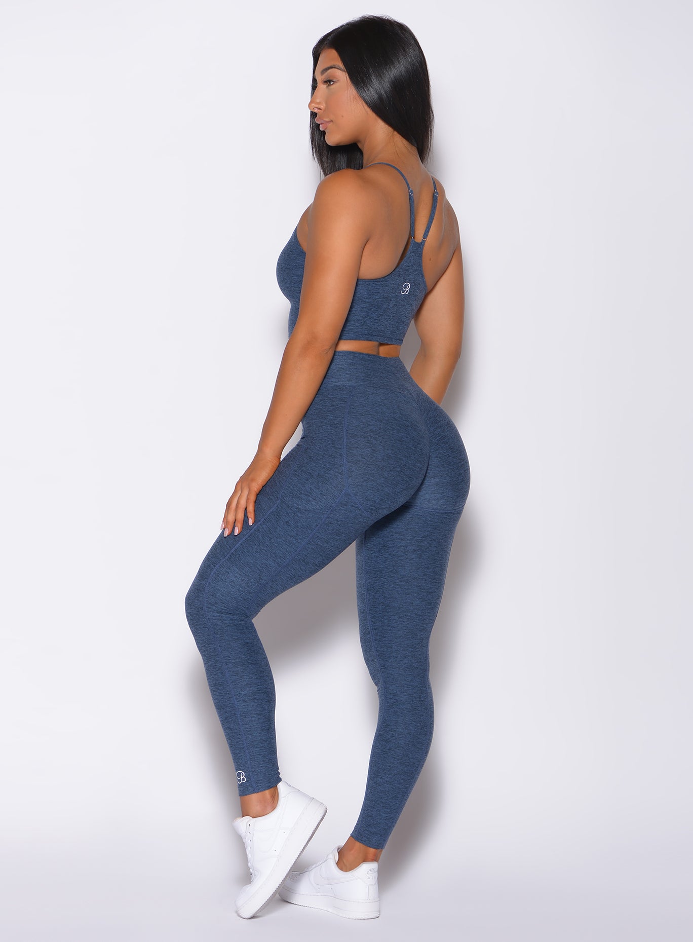 Left side profile view of a model facing forward wearing our relax long bra in night sky color and a matching leggings