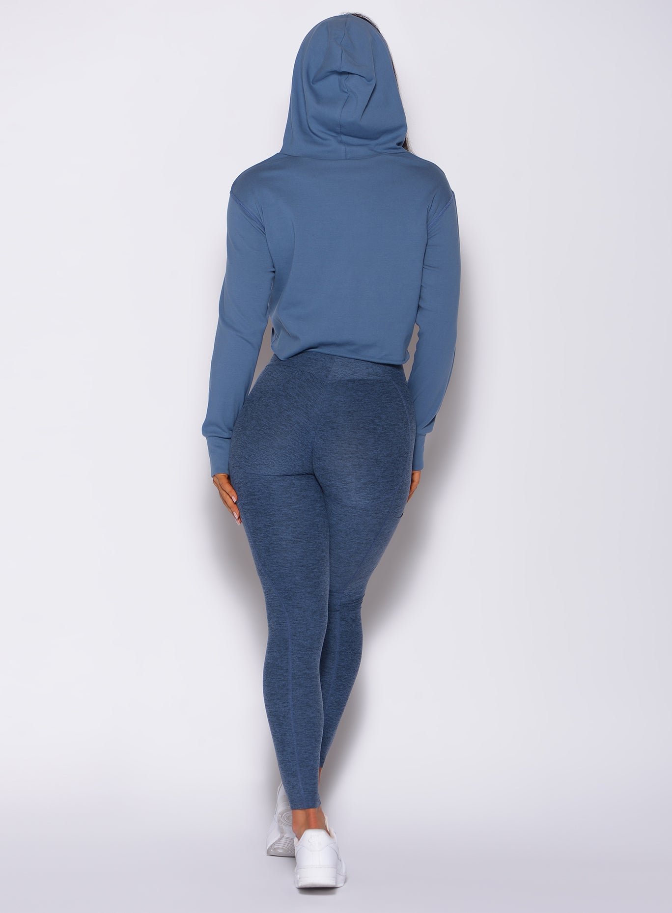 back profile view of a model in our uplift pocket leggings in night sky color and a matching hoodie 