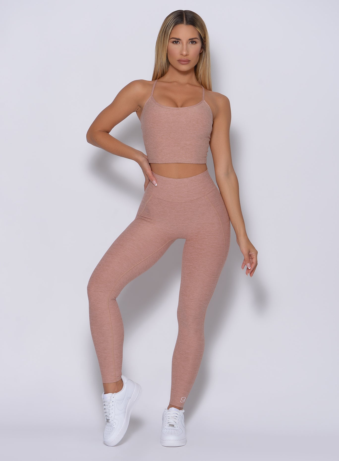 Front profile of the model in our uplift leggings in latte color and a matching top