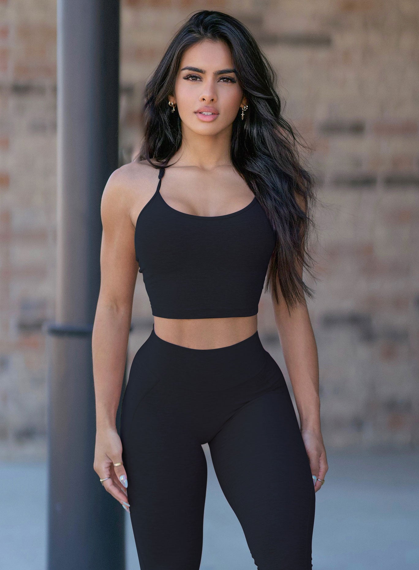 Front profile picture of a model in our black relax long bra and a matching leggings 