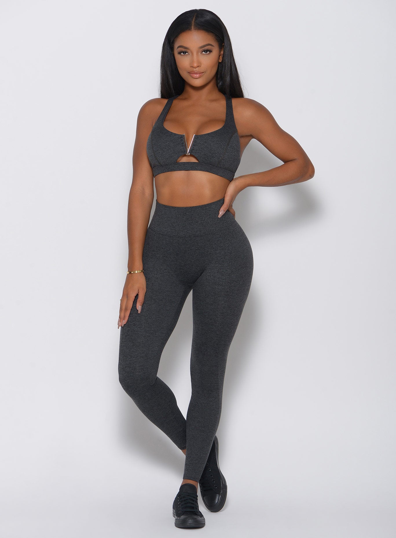 Front view of the model in a high waist gray leggings with a V back design