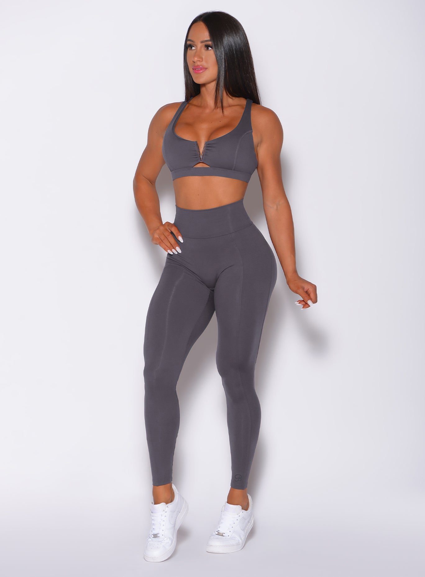 Front profile view of a model in our victory scrunch leggings in shadow color and a matching sports bra
