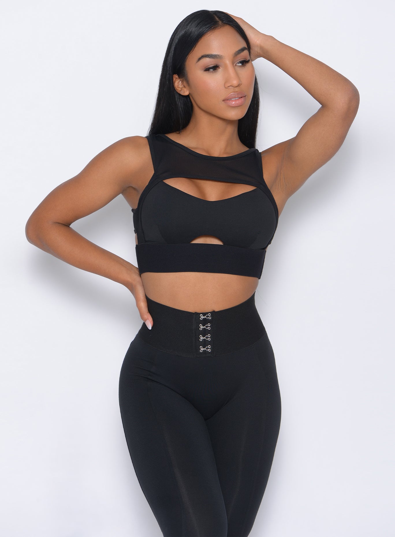 Front profile view of the model holding her hair wearing our volume sports bra and a matching leggings