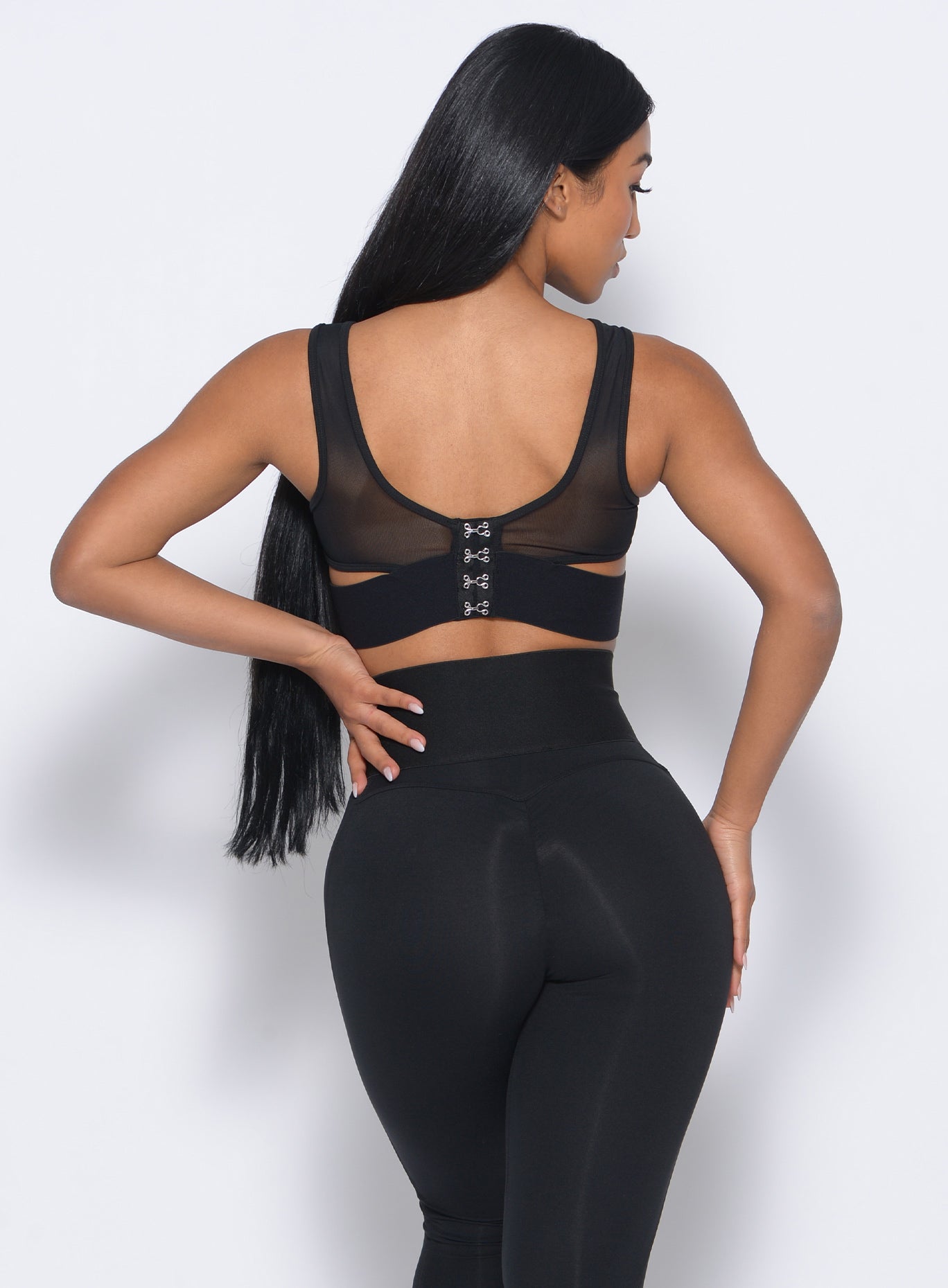 Back profile view of the model in our volume sports bra and a black leggings 