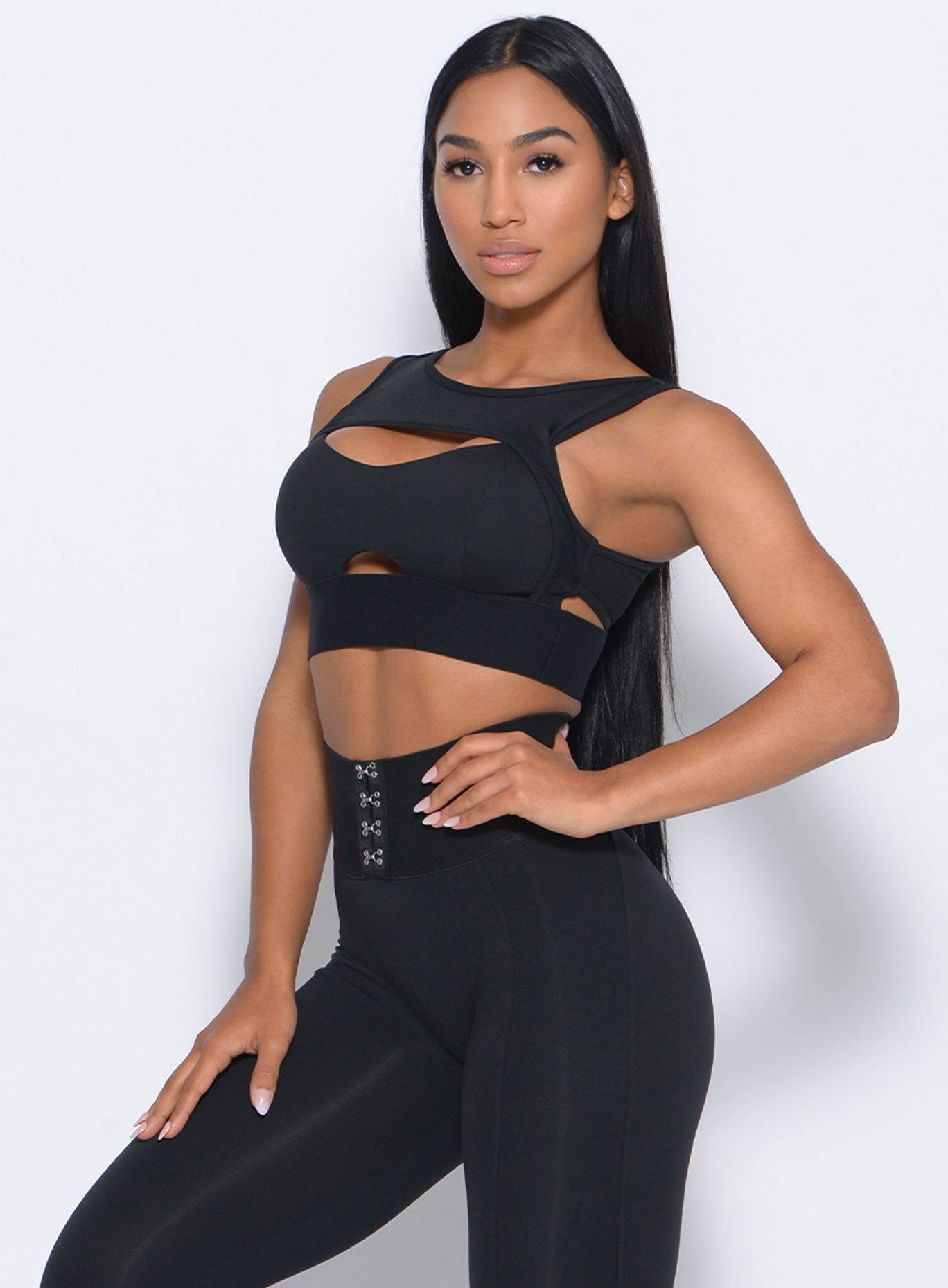 Front profile view of the model with her left hand on waist wearing our volume sports bra and a matching leggings 