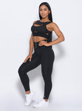 Left side view of the model angled left in our black waist cincher leggings and a matching bra