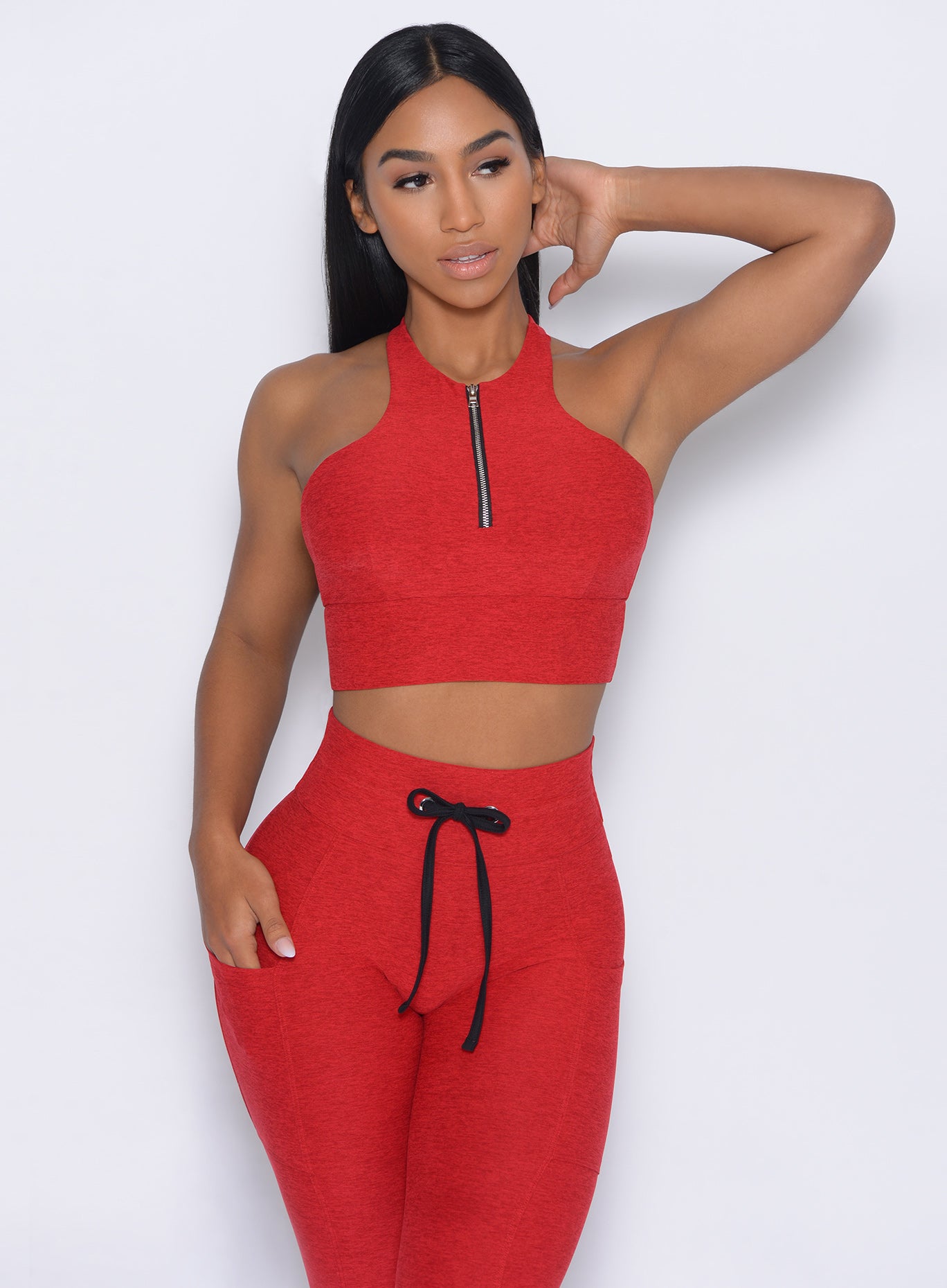 Front profile view of the model in our edgy longline bra in sunset red color and a matching leggings