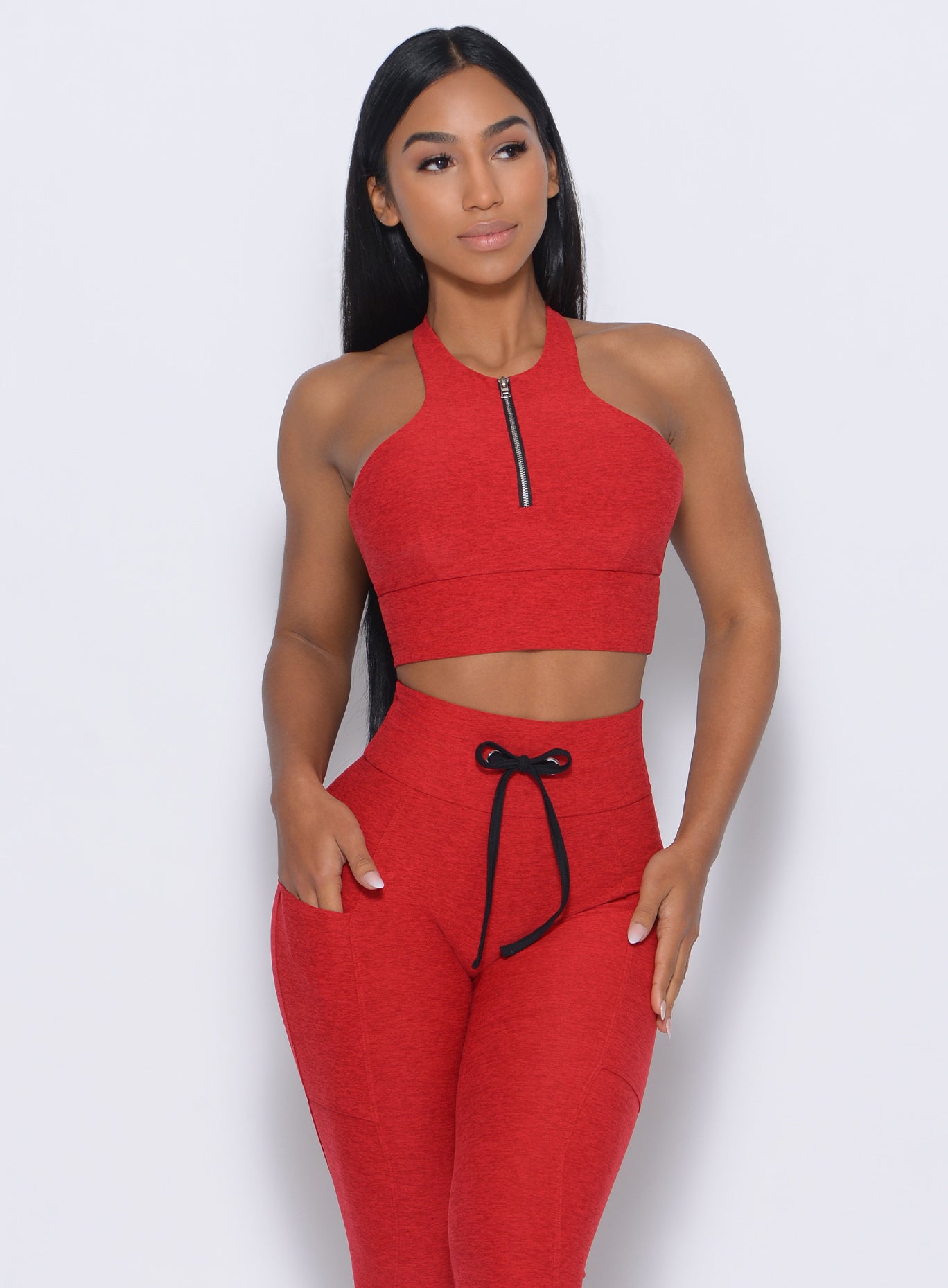 Model facing forward in our edgy longline bra in sunset red color and a matching leggings