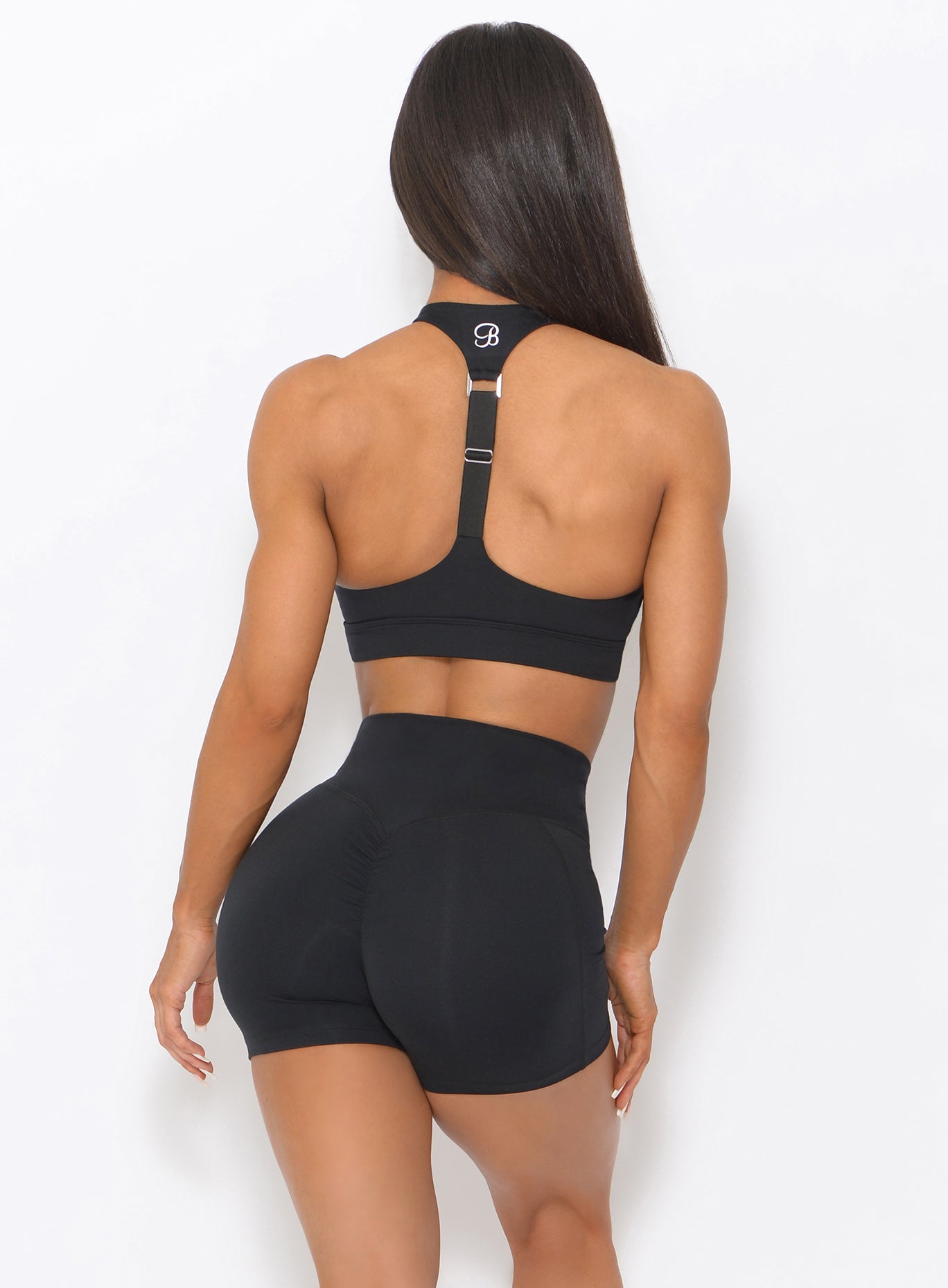 Back view of the model wearing our black weightlifter bra and a matching shorts