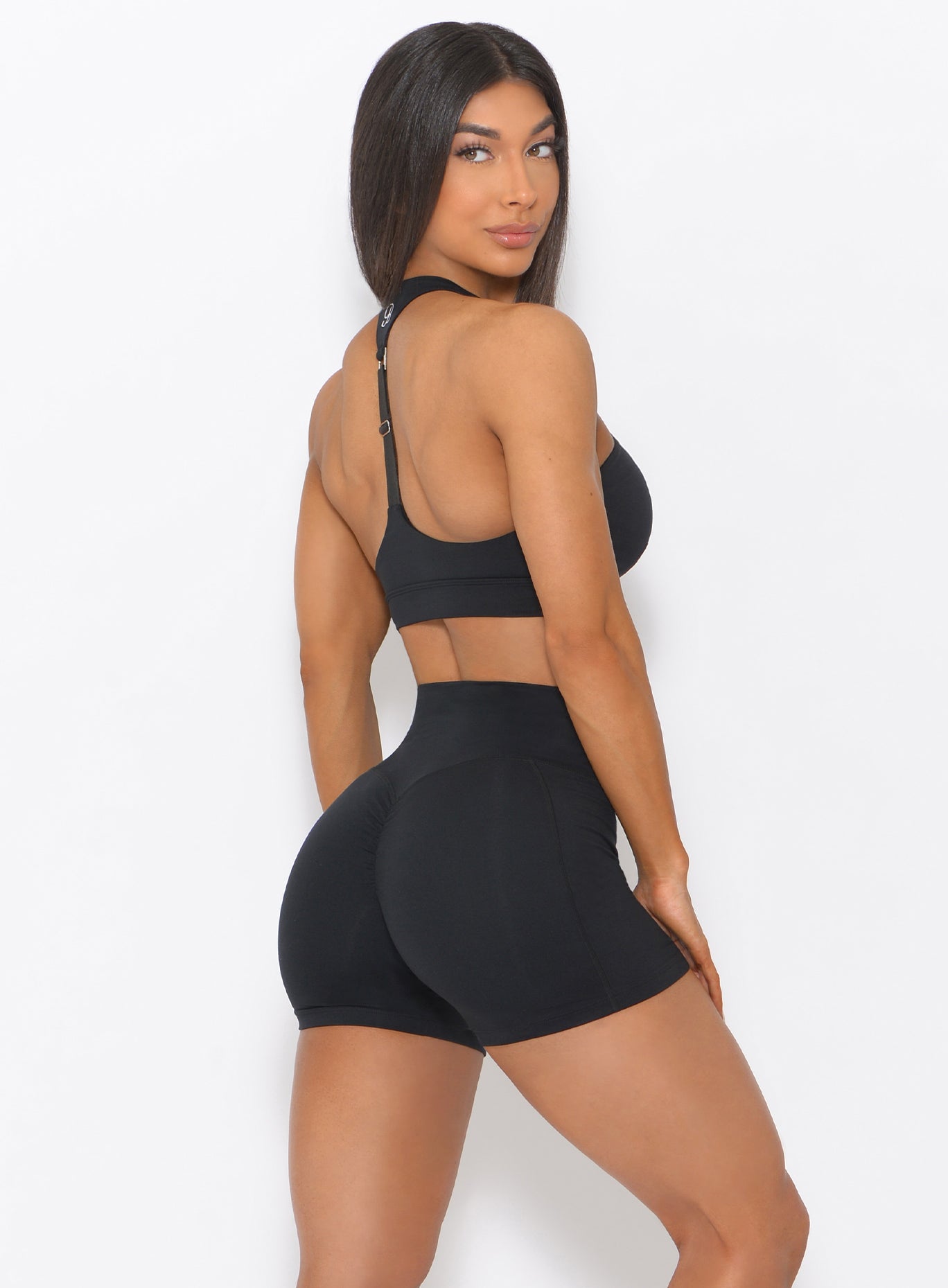 Right side view of the model in our black weightlifter bra and a matching shorts